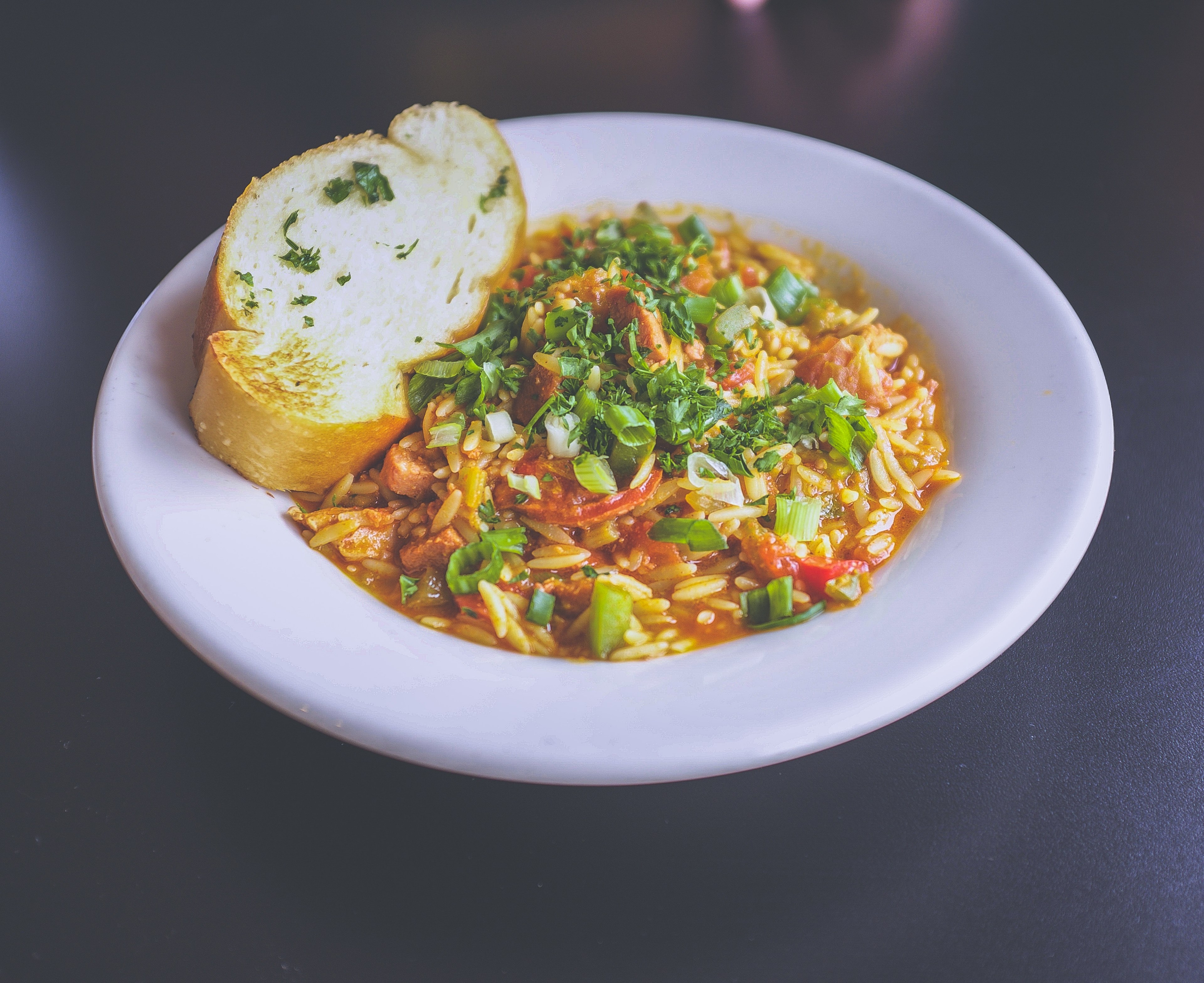 rice pasta dish garnished with green onions and parsley with a slice of garlic bread served in a ceramic bowl, foooood 4k, HD Wallpaper
