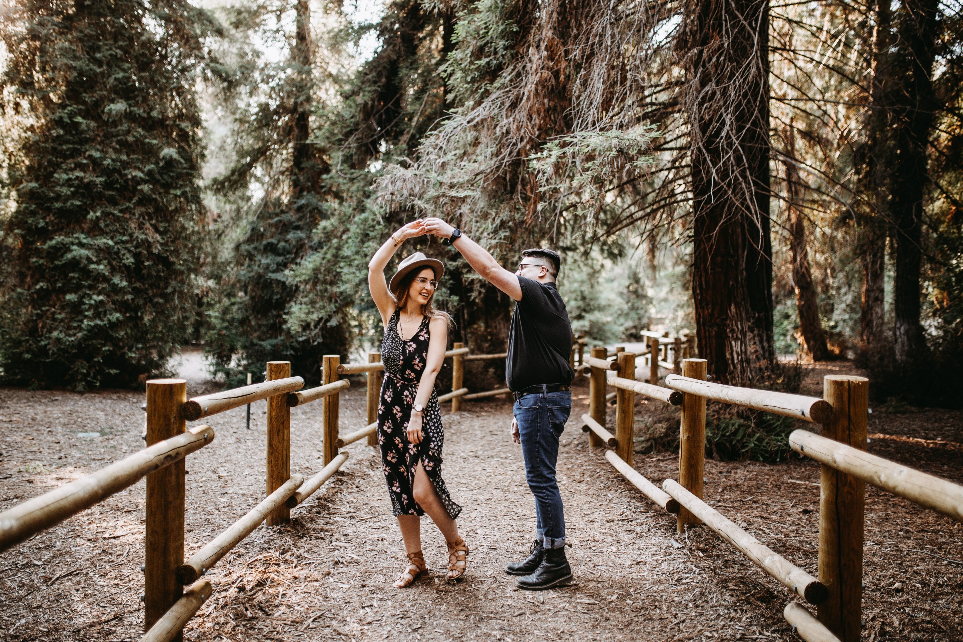 a man and a woman dance holding hands on a fenced in pathway in the woods, surprise proposal in the redwoods 4k, HD Wallpaper