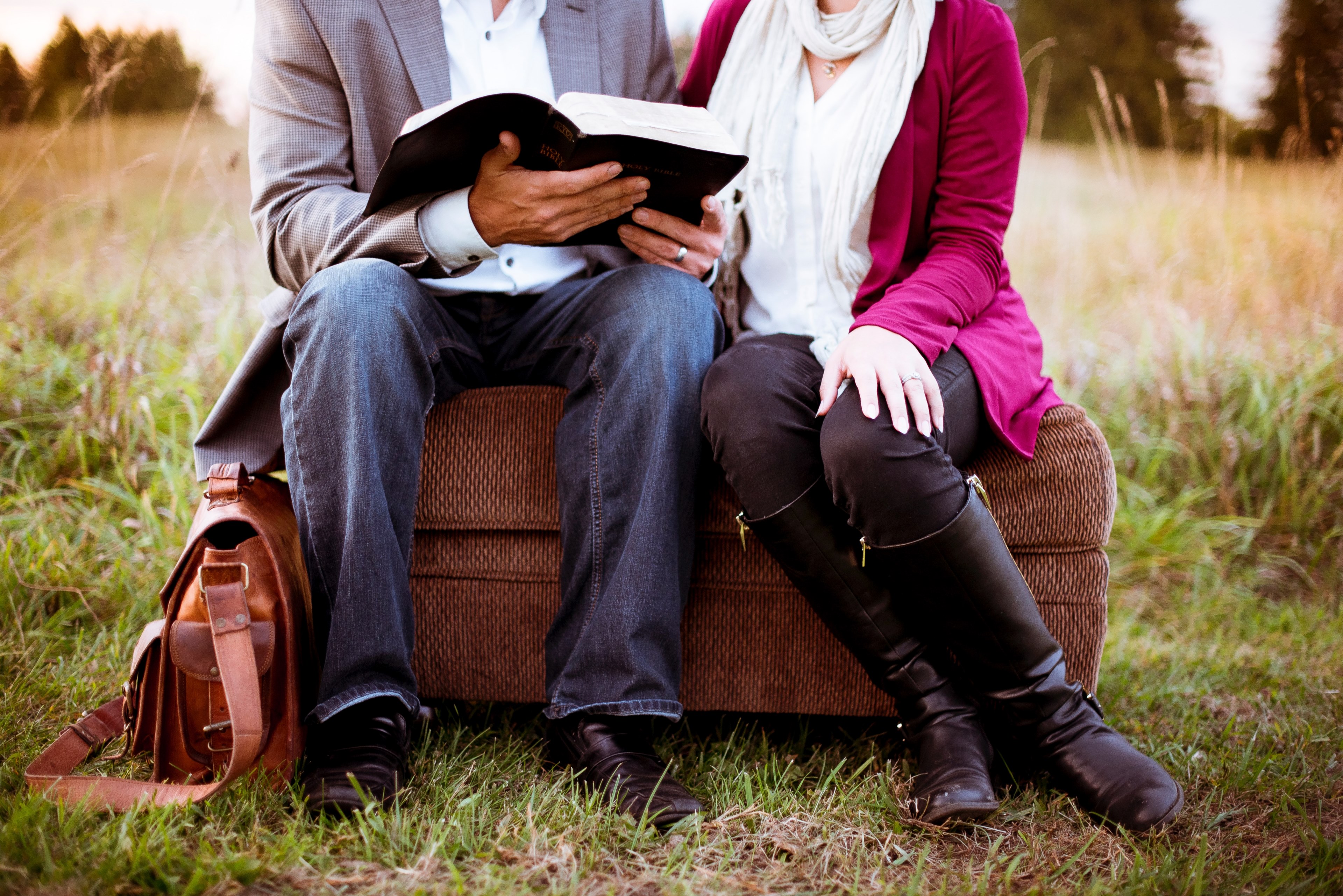 a married couple sitting on an ottoman outdoors he is reading a book, _man reading book on ottoman 4k, HD Wallpaper