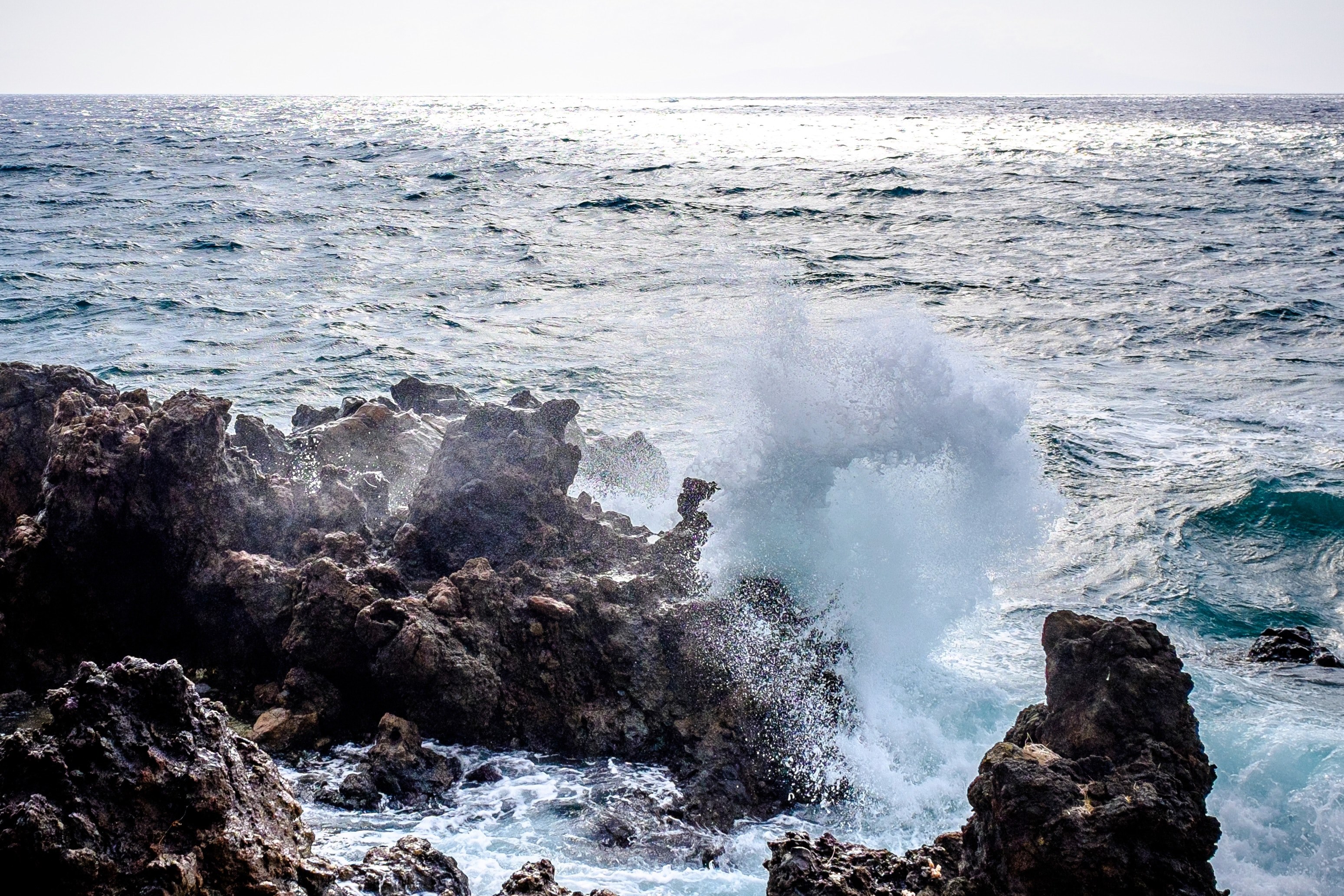 a wave breaking and splashing up onto rocks along the coast of maui, breaking waves 4k, HD Wallpaper