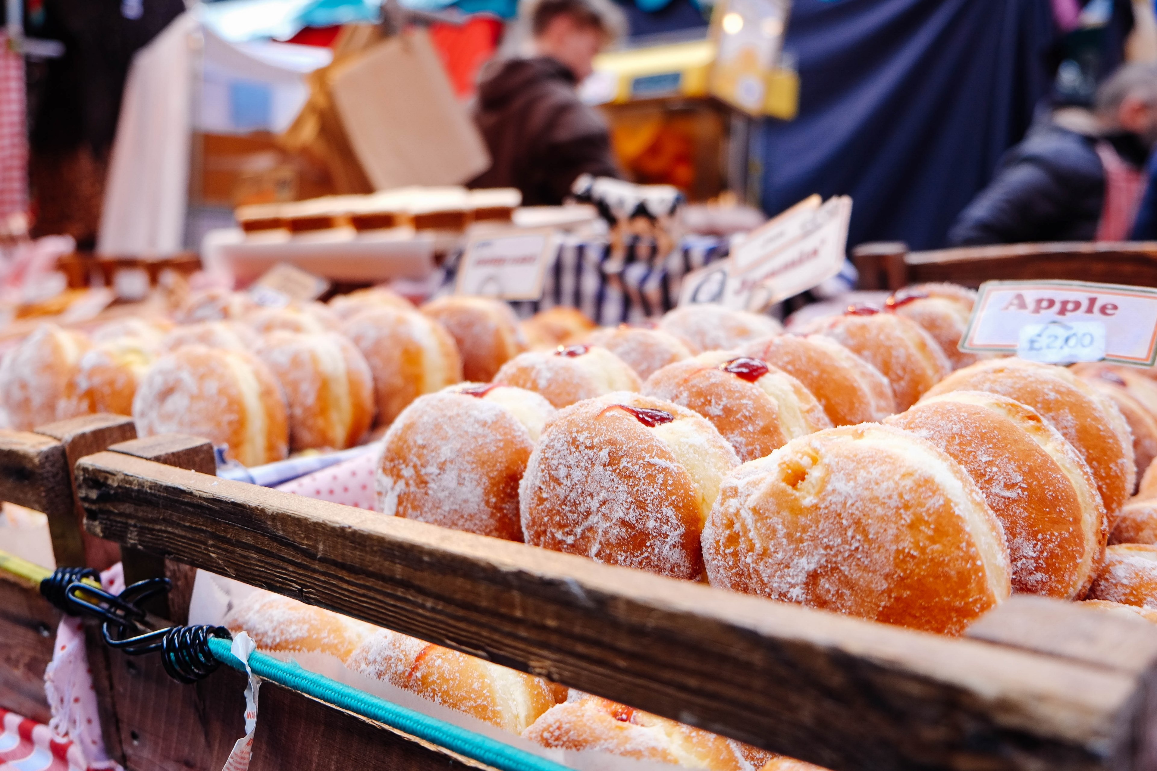 fresh donuts with red filling on display in a market filled with people, jelly doughnuts 4k, HD Wallpaper