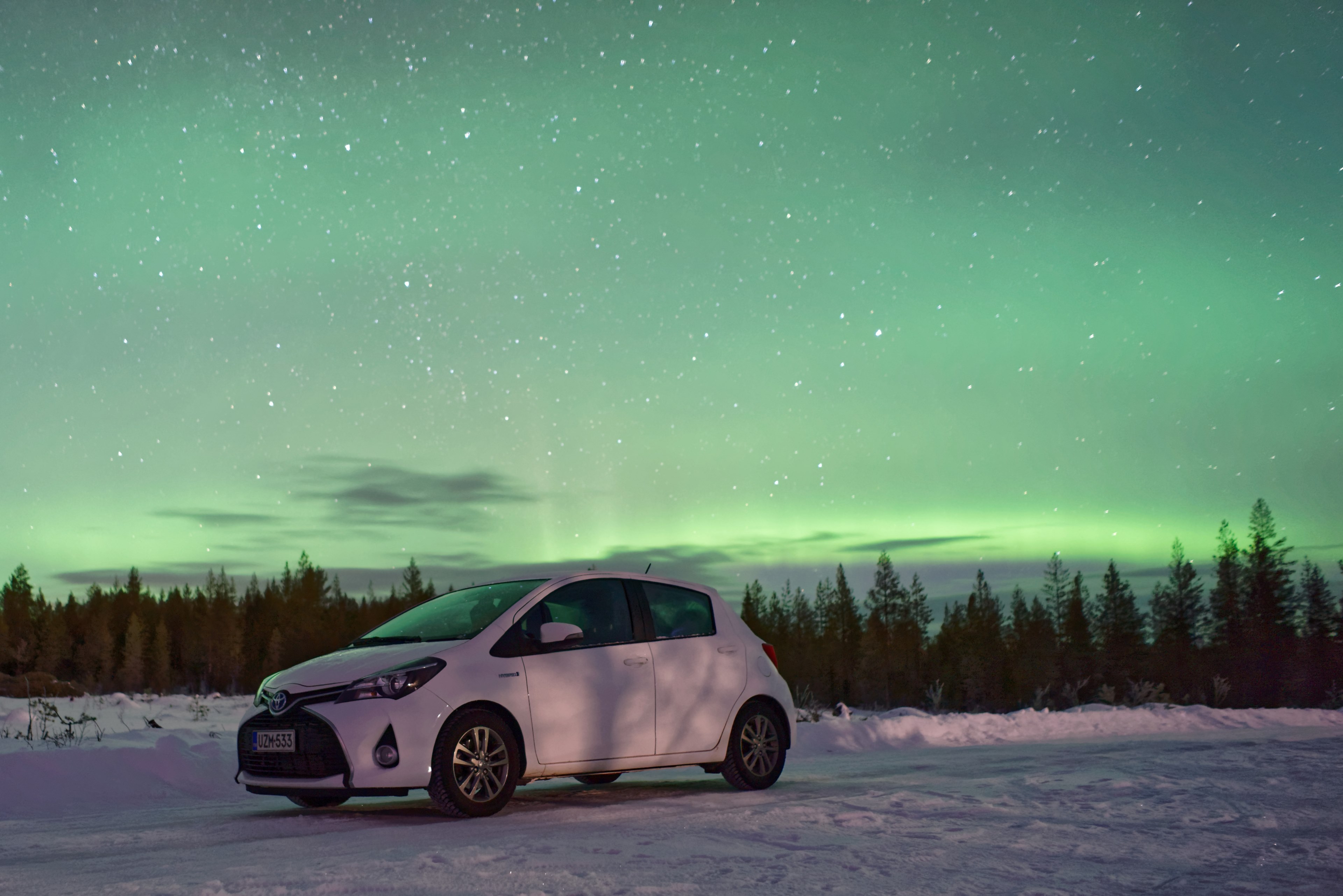 a newer white hatchback parked in the snow with a bright aurora boreali in the sky above, toyota yaris behind aurora borealis 4k, HD Wallpaper