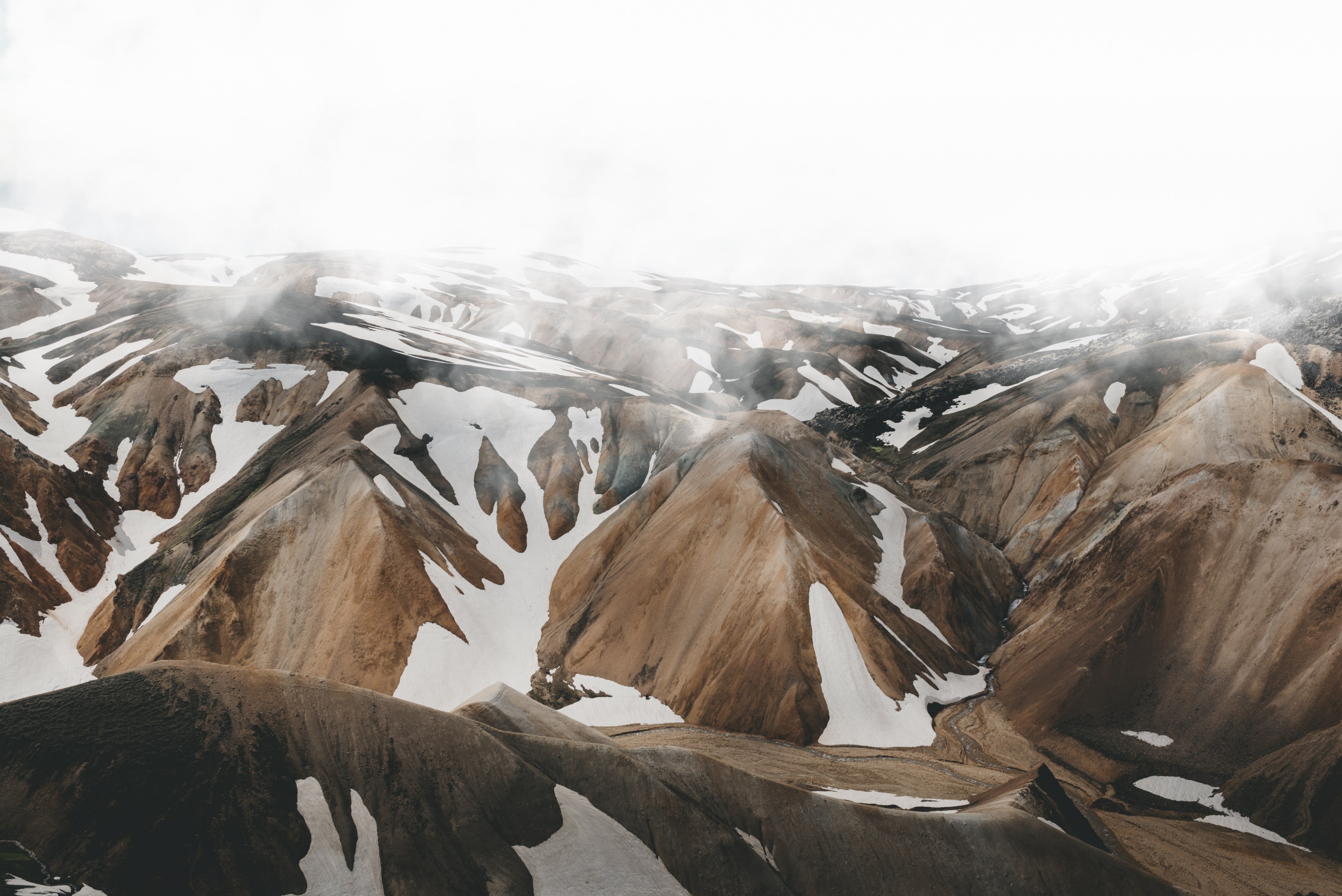 icelandic mountain range with spots of snow sit below a foggy sky, mountain under mist 4k, HD Wallpaper