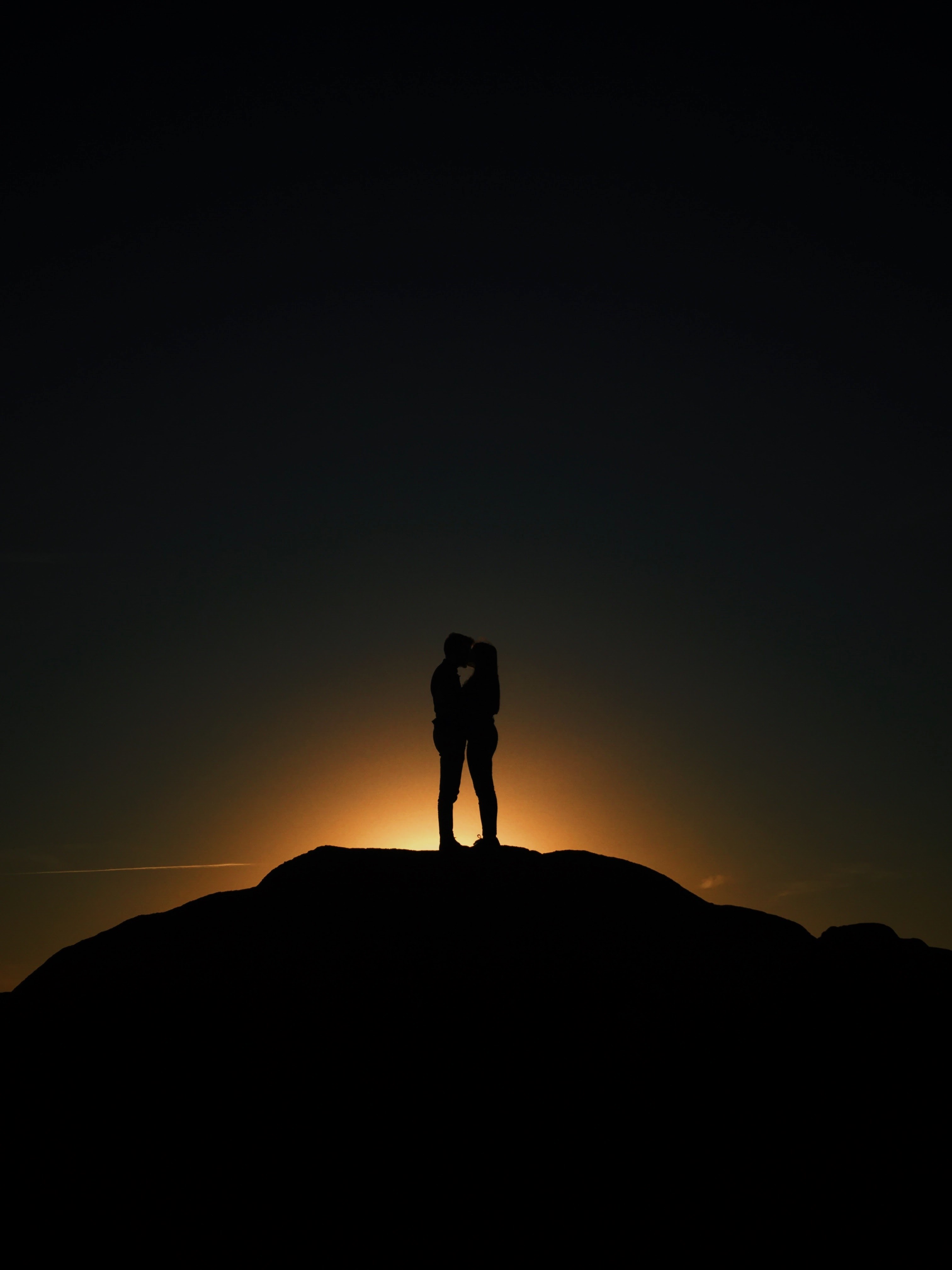 standing on a hilltop the setting sun silhouettes a couple kissing, hilltop kiss 4k, Phone HD Wallpaper