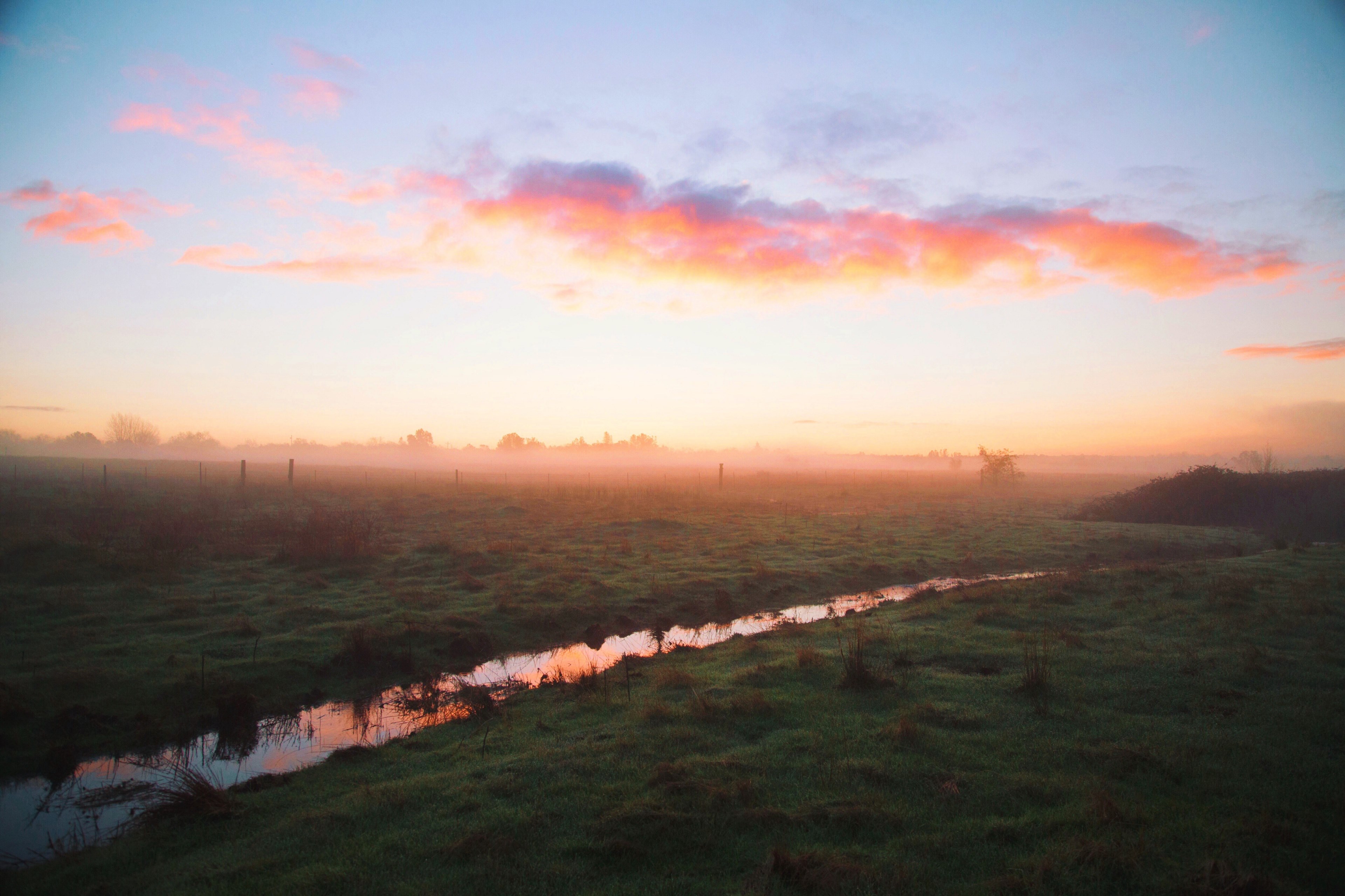 a countryside field with a small stream reflecting the pink blue and orange sky during sunset, countryside sunset 4k, HD Wallpaper
