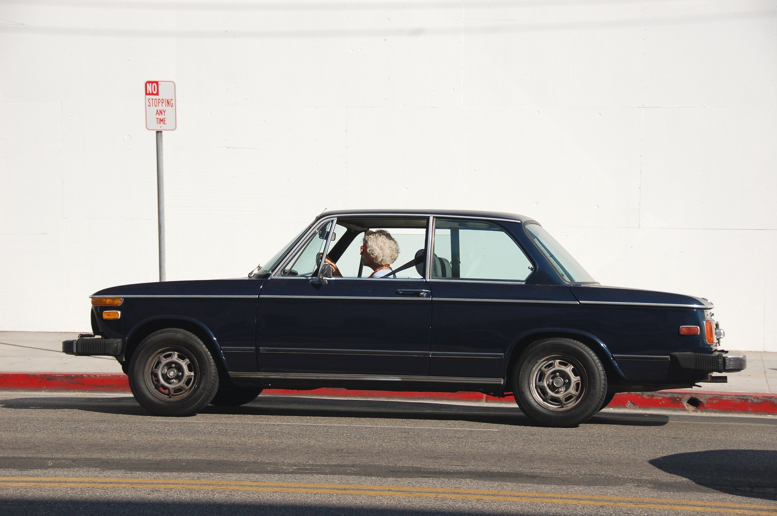 old woman driving through an empty urban street in a dark blue car beverly hills, old woman driving blue car 4k, HD Wallpaper