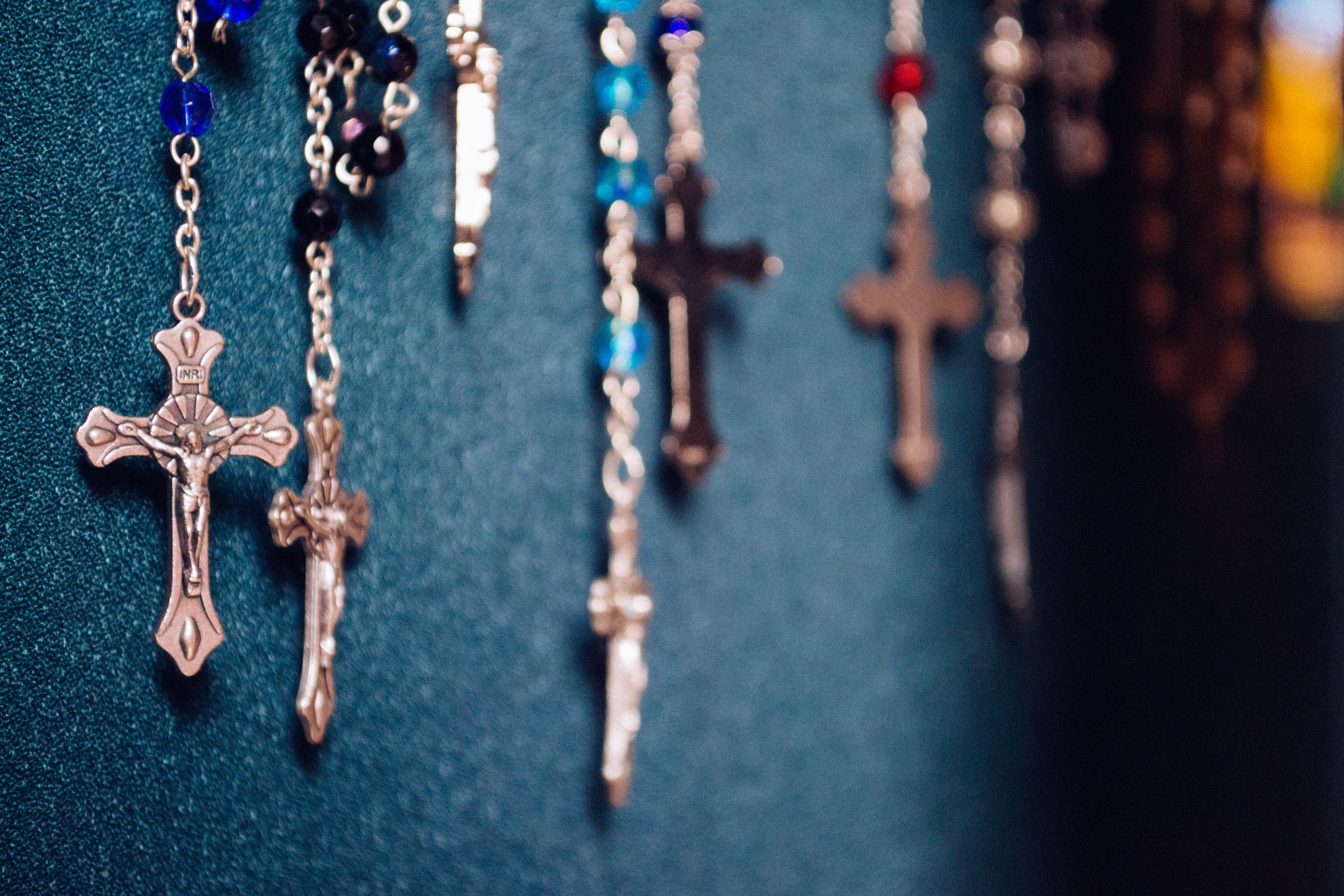 cross pendants on gem necklaces hanging down a wall, _cross shaped pendants 4k, HD Wallpaper