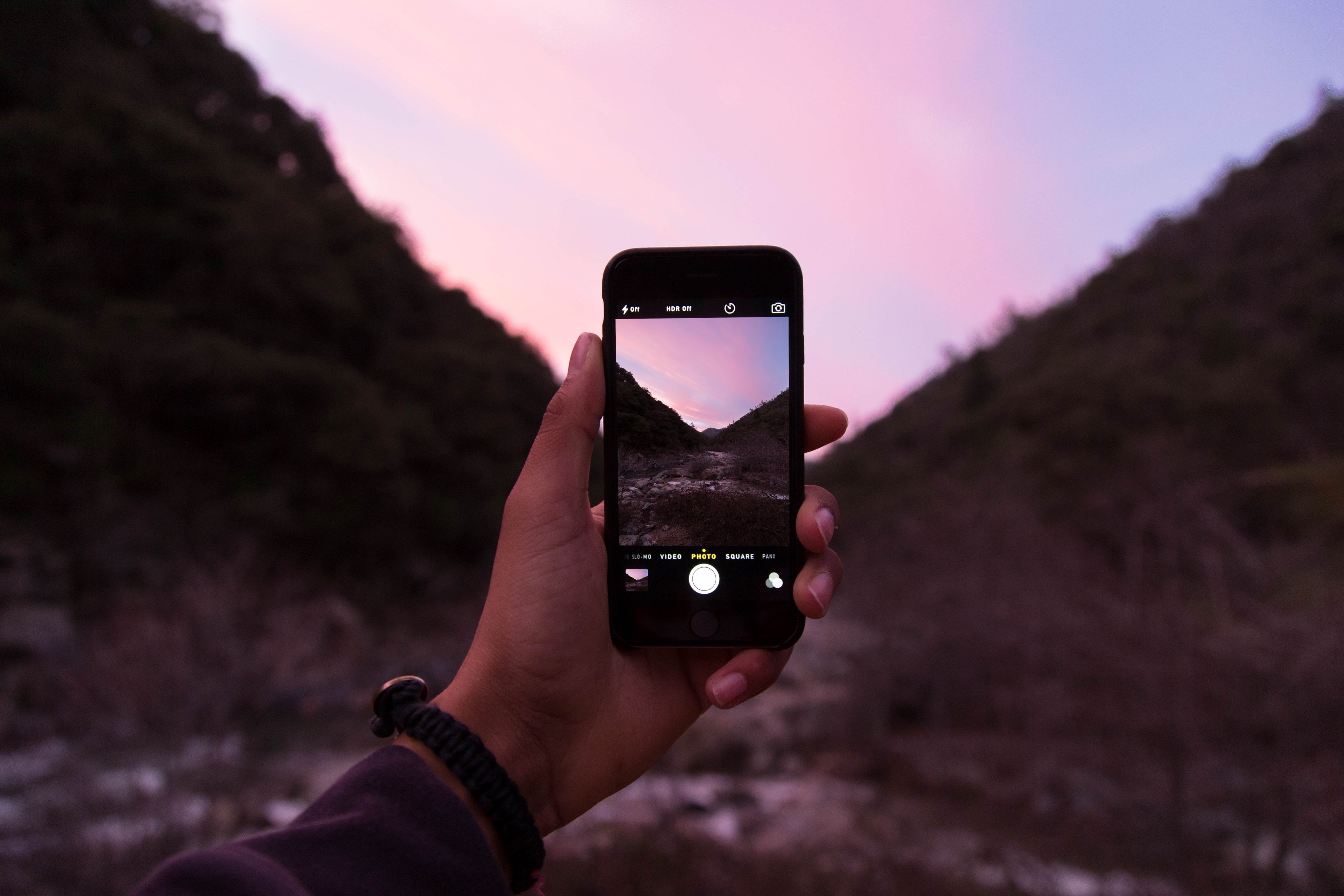 a person taking a photo of a pink sky and mountain with an iphone cellphone, iphone sunset photos 4k, HD Wallpaper