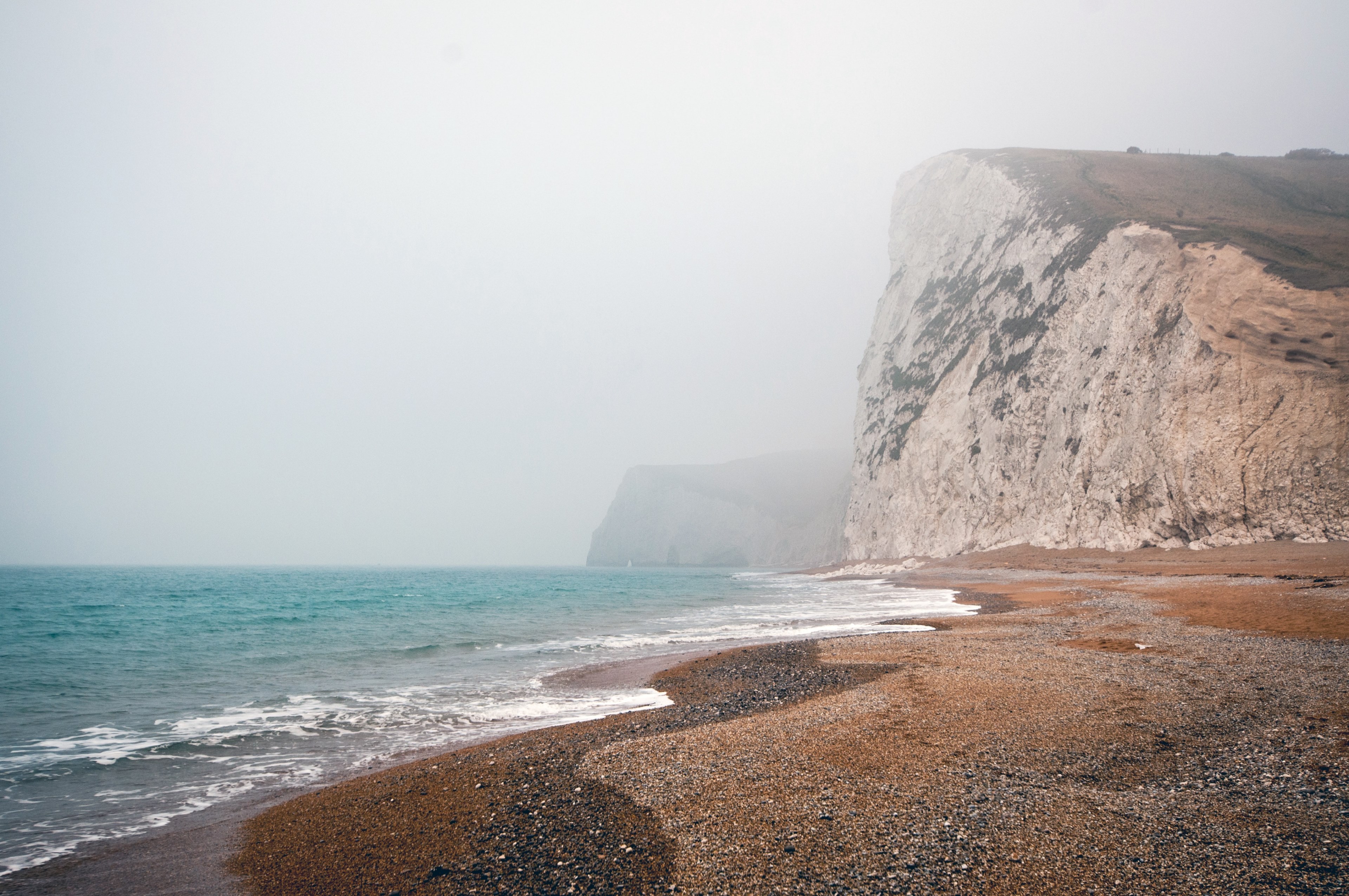 bluffs line the seashore of a foggy ocean beach, cloudy coastline 4k, HD Wallpaper