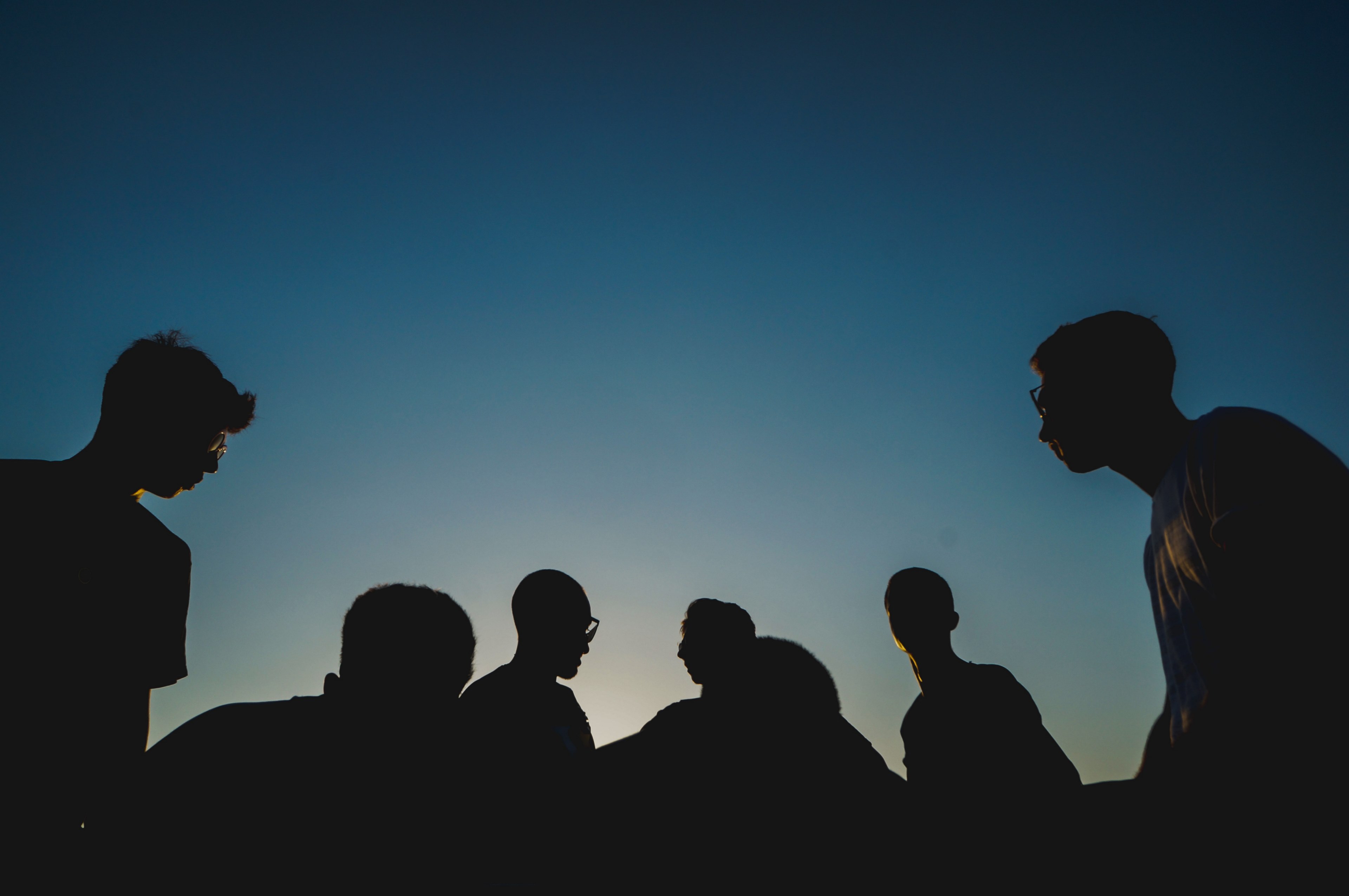 a group of many people gathered together in silhouette against a blue sky, people in silhouette 4k, HD Wallpaper