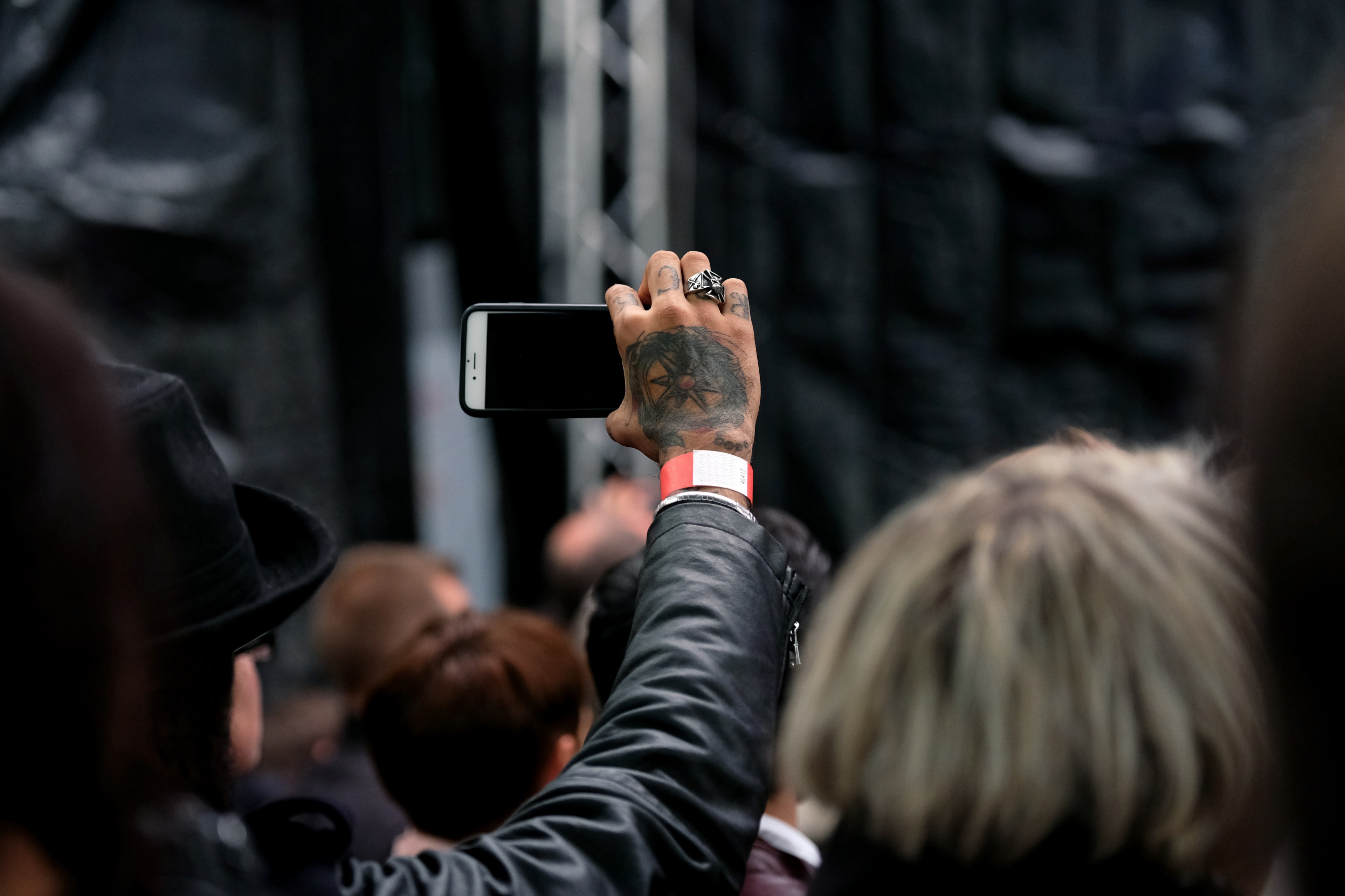a man with a tattooed hand holding a smartphone while standing in a crowd, _crowd holding smartphone 4k, HD Wallpaper