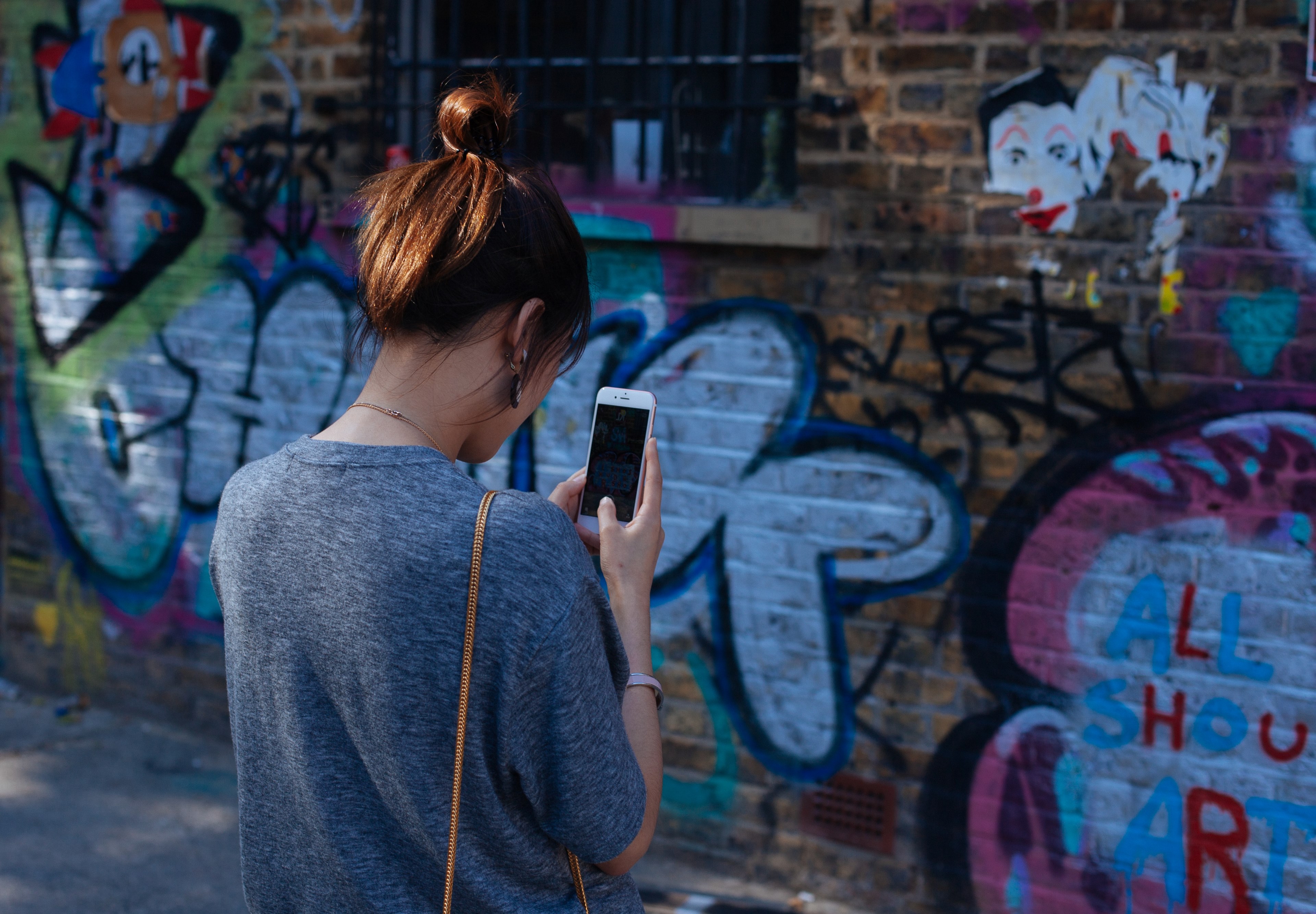 young woman on iphone with grey jumper taking picture of graffiti on wall at brick lane, woman takes picture of graffiti 4k, HD Wallpaper