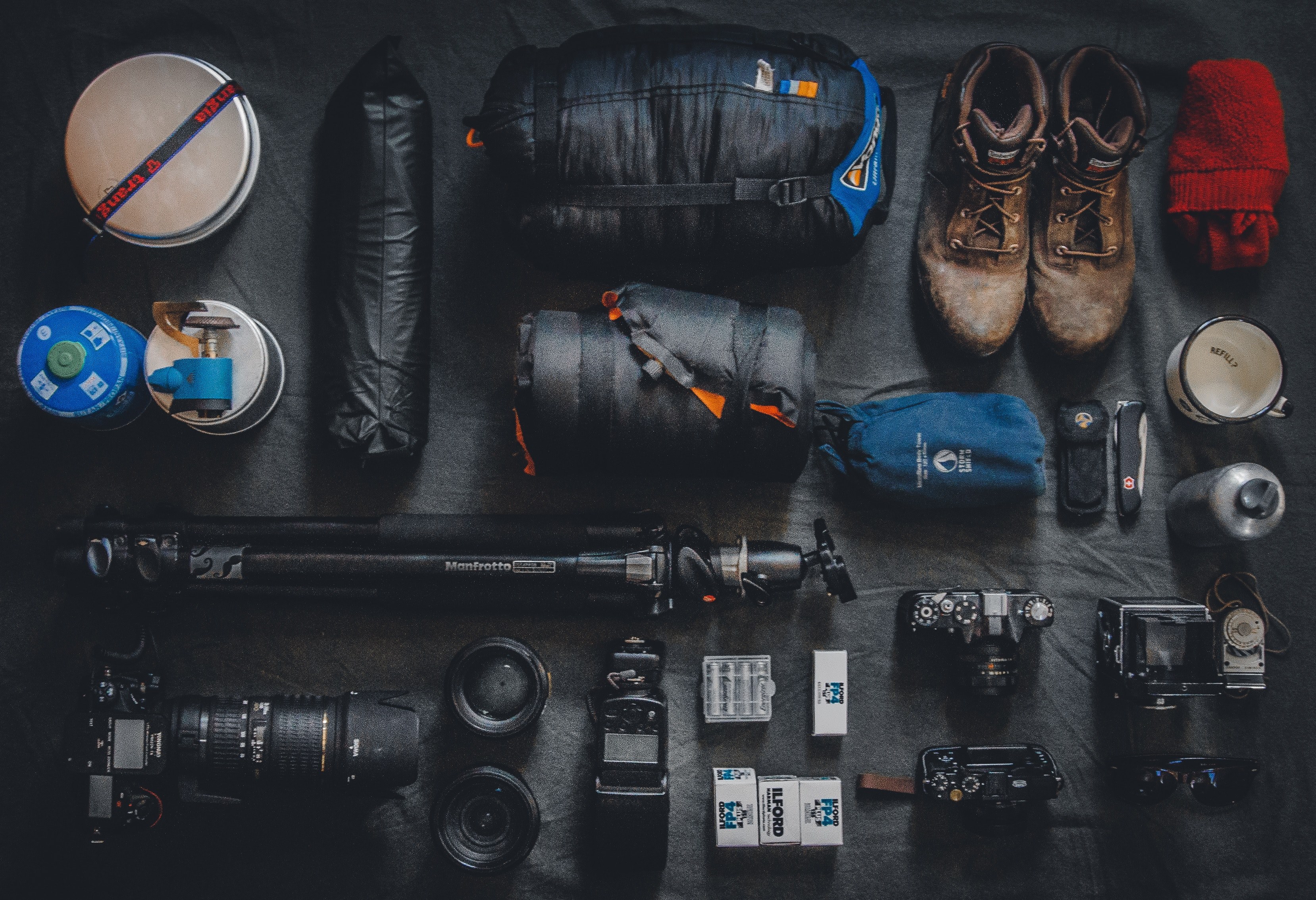 neatly arranged boots and photography equipment including camera lens tripod sleeping bag and mug, the photographers backpack 4k, HD Wallpaper