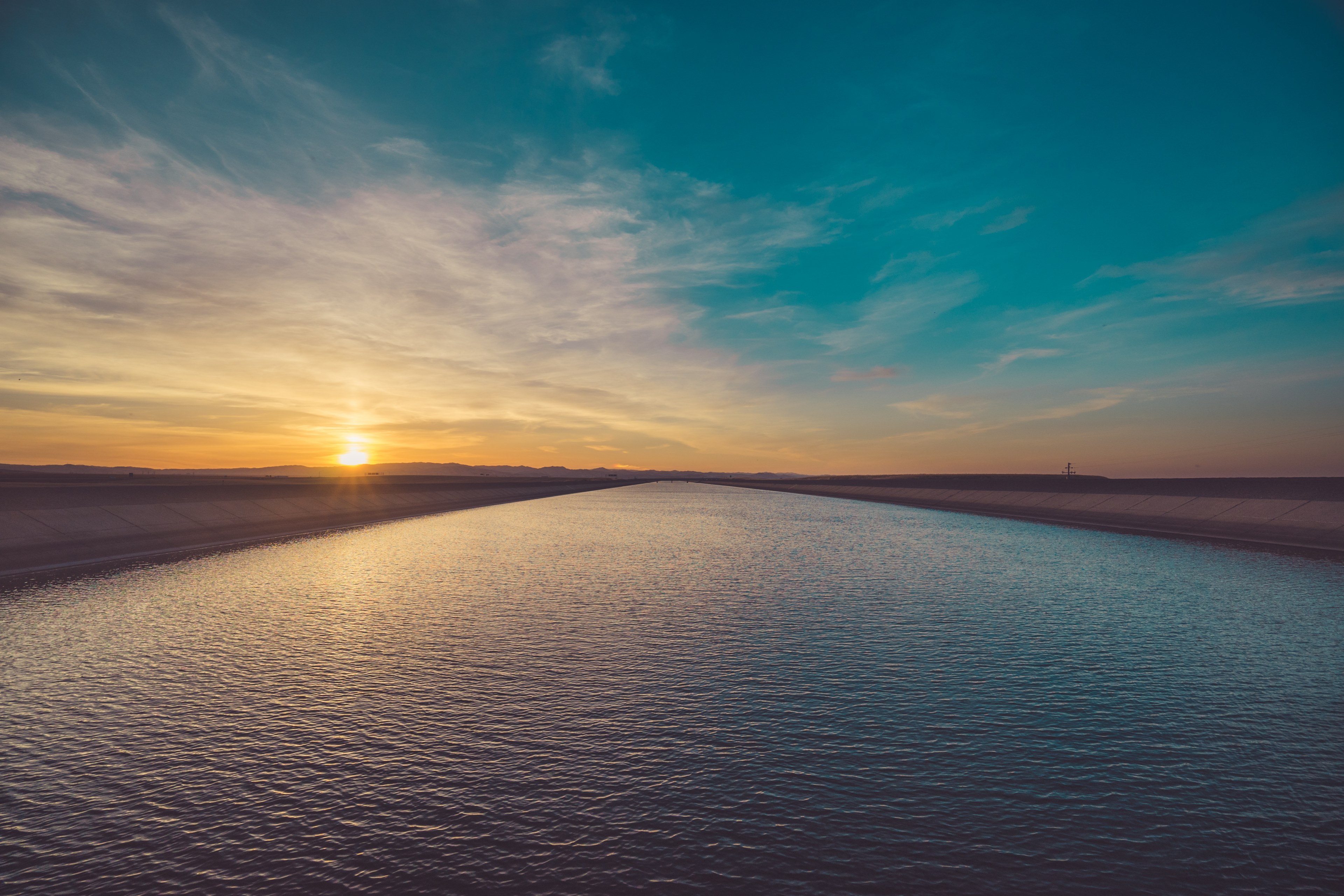 a low sunset is reflected in the rippled water of a lake with gold and turquoise sky, twilight lake sunset_ 4k, HD Wallpaper