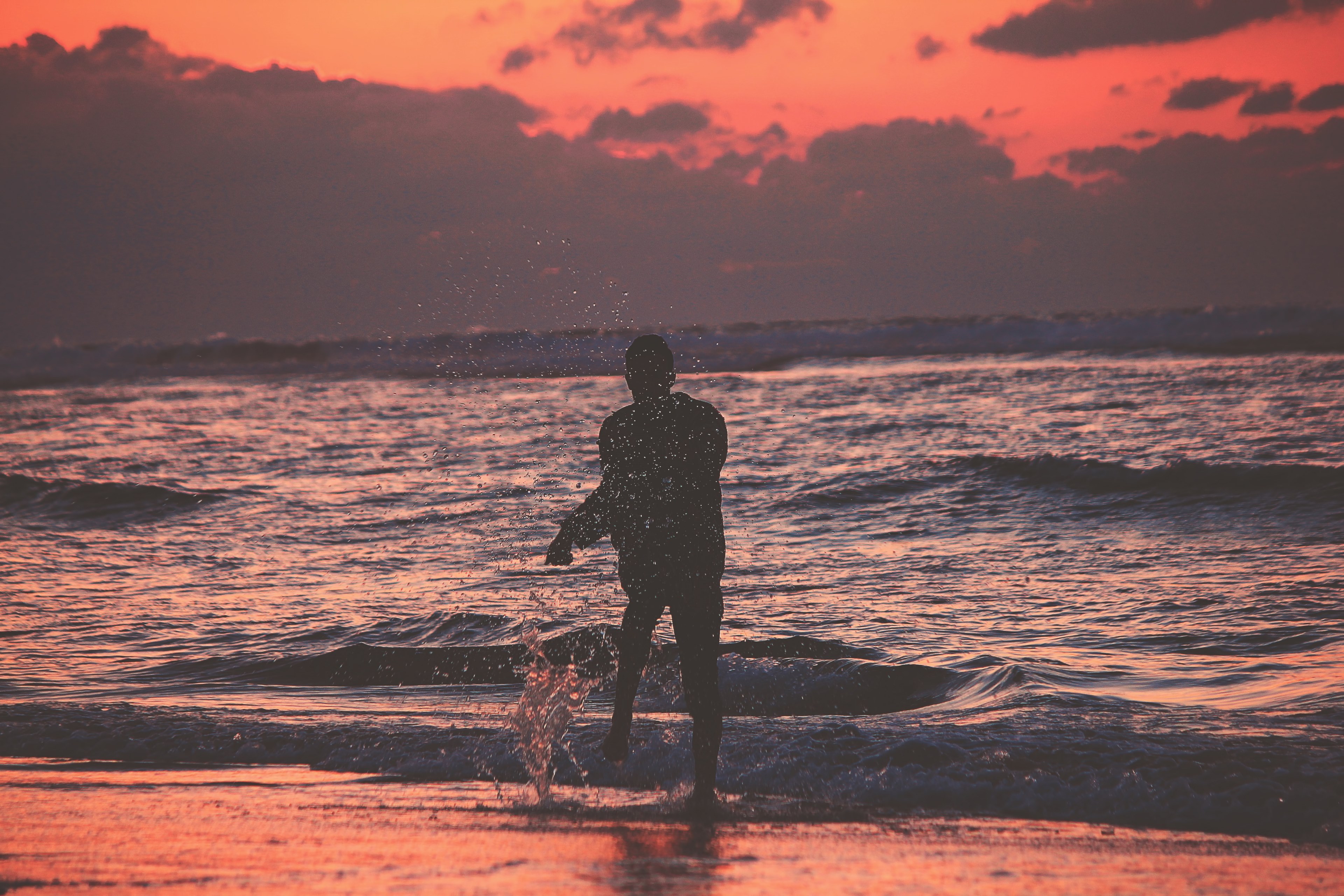 person standing on a beach splashing after sunset in asilah, splash life 4k, HD Wallpaper