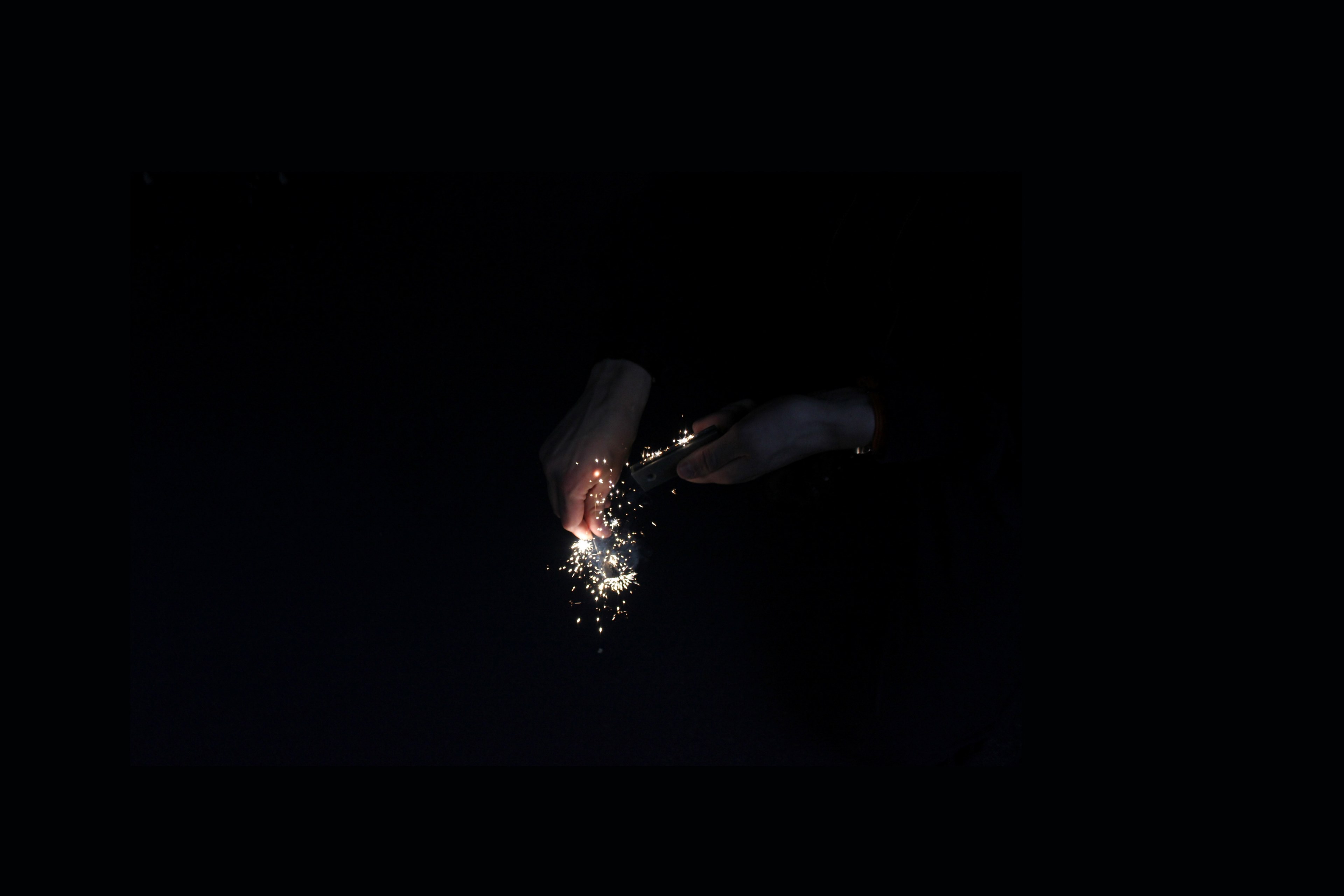 hands ignite golden sparks using a flint in the dark, sparks fly 4k, HD Wallpaper