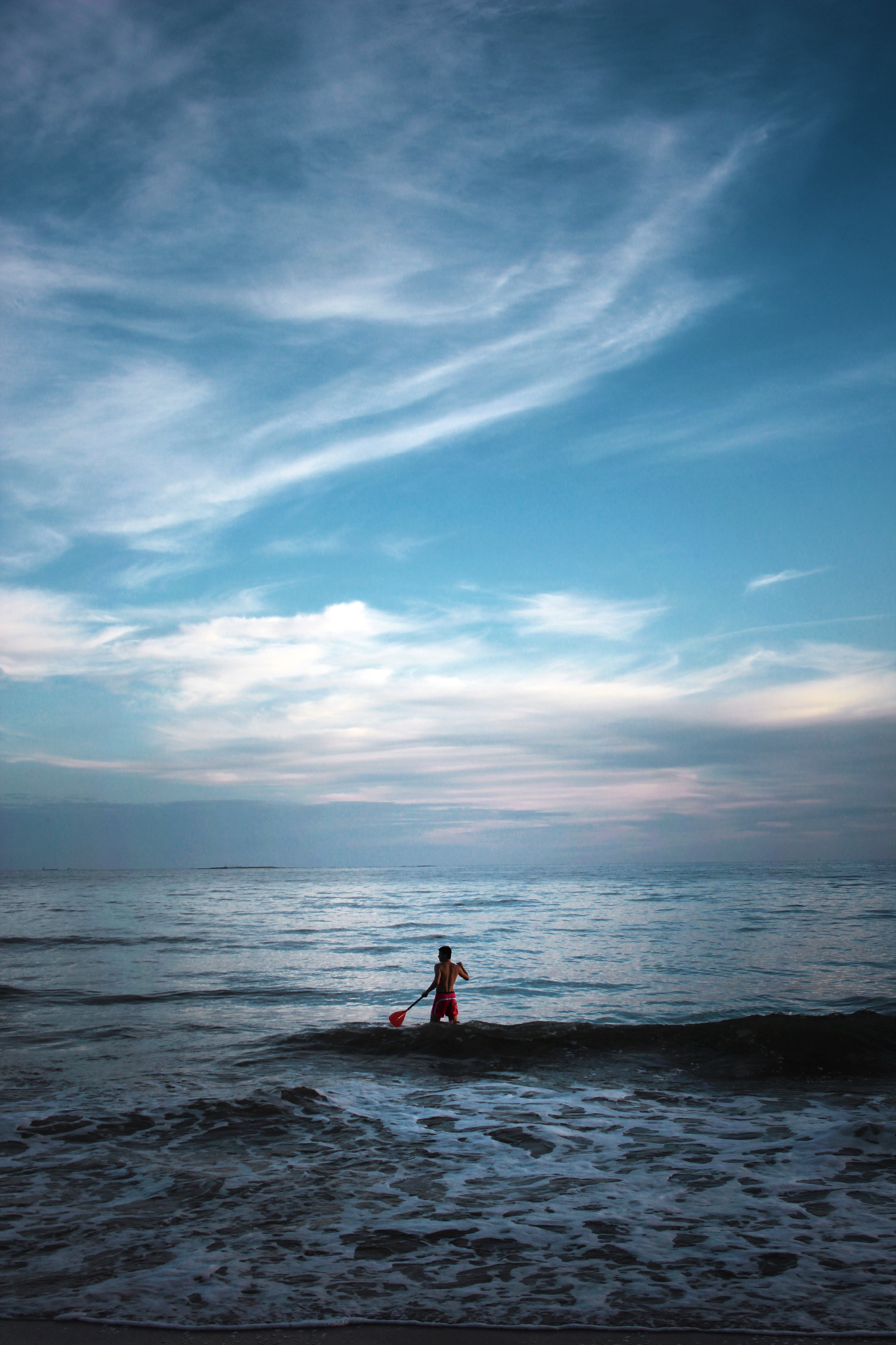 a paddleboarder on a calm sea beneath a blue dusky evening sky, evening paddleboarding 4k, Phone HD Wallpaper