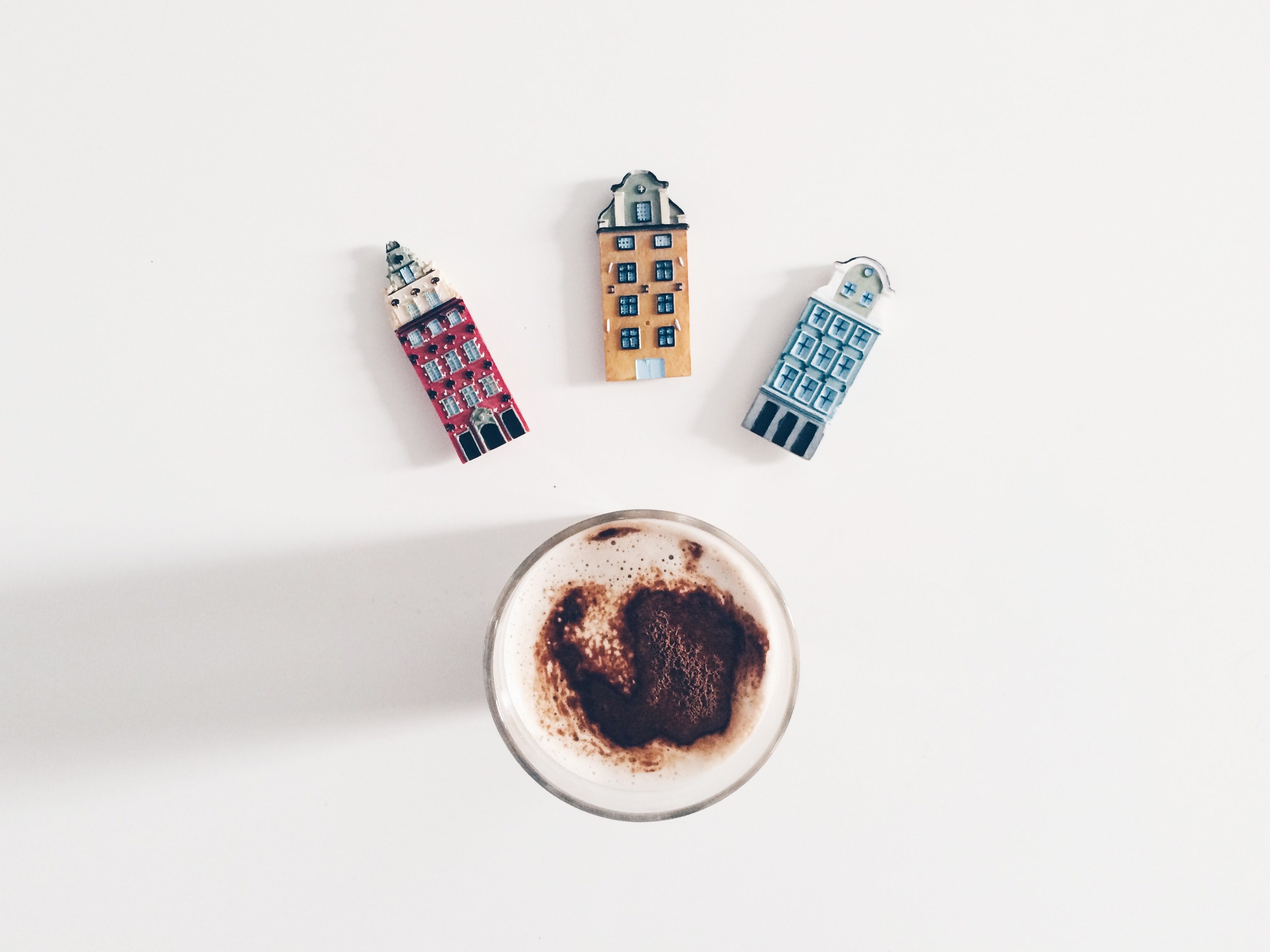 cappuccino in a clear glass with three magnets in the shape of buildings above the glass, london latte 4k, HD Wallpaper