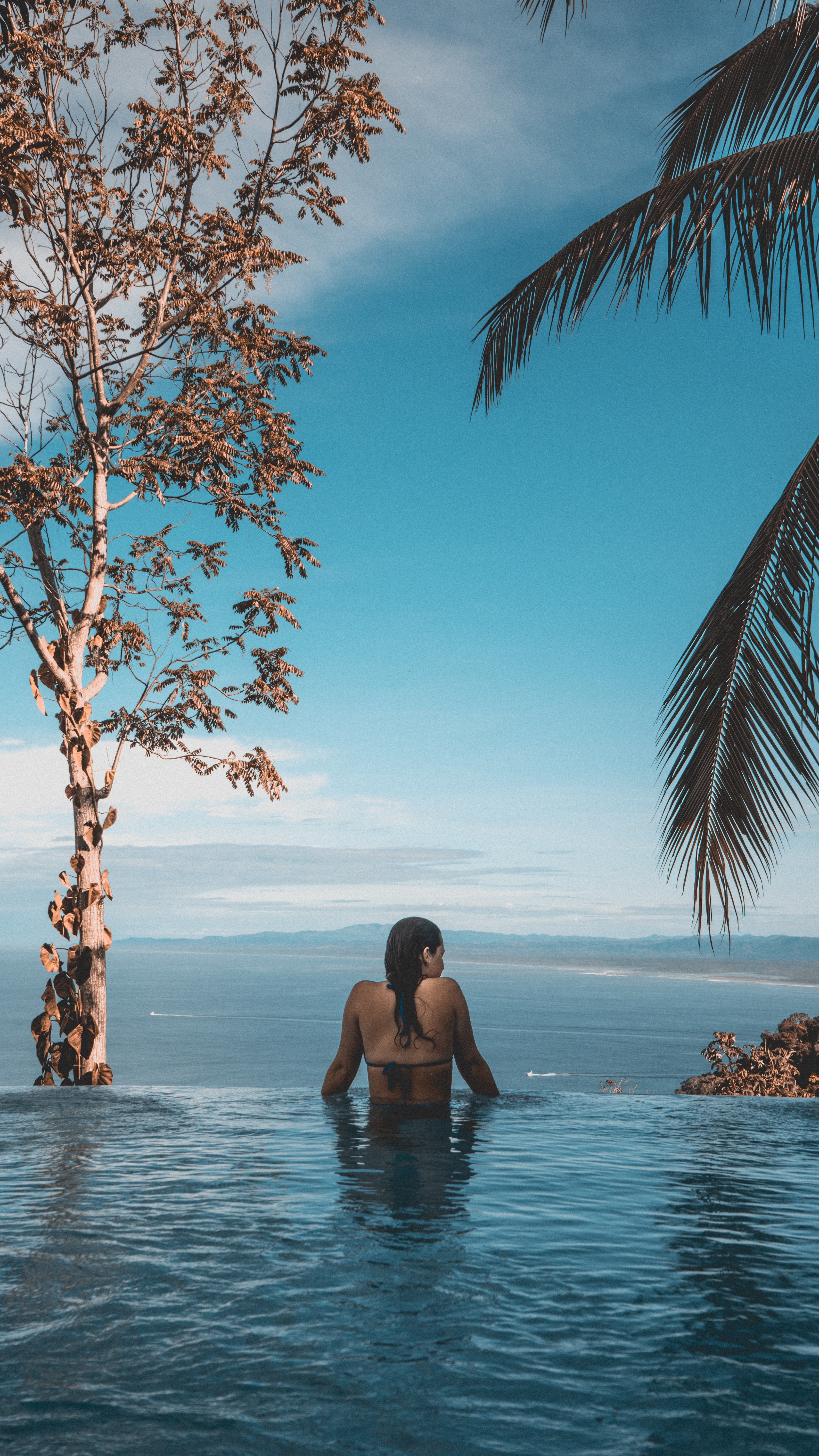 woman on the edge of the infinity pool by the tropical trees at manuel antonio beach, wild 4k, Phone HD Wallpaper