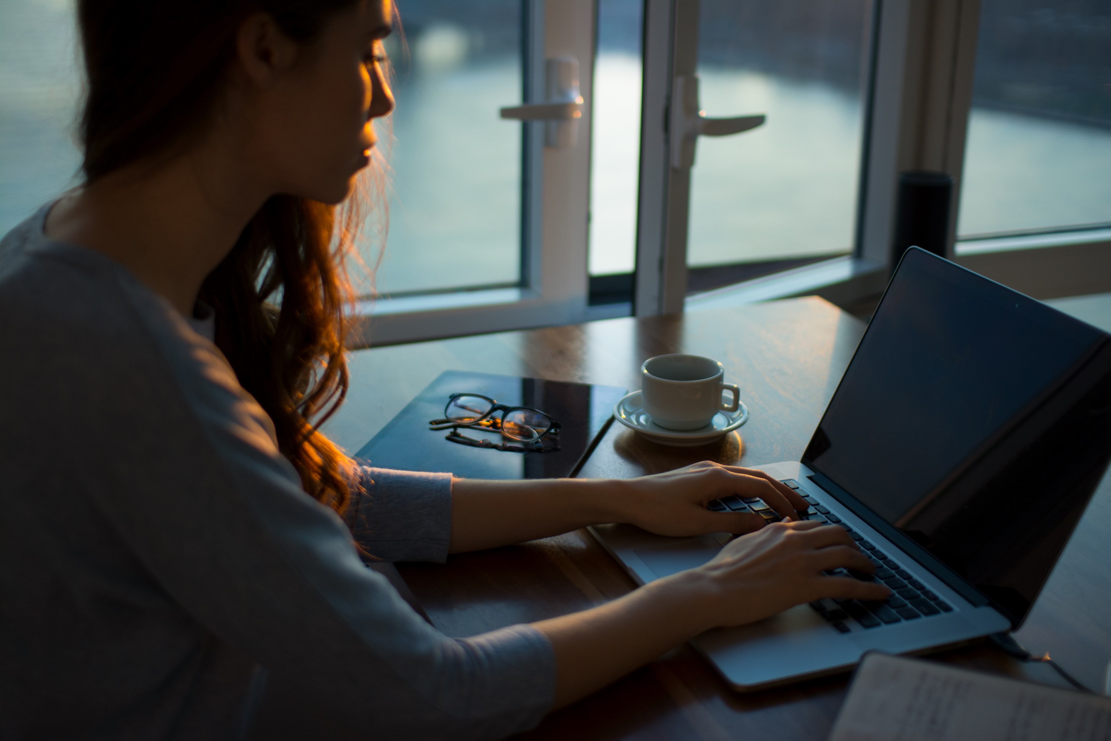 a woman working at a laptop near a half open window, woman works from home on her laptop 4k, HD Wallpaper