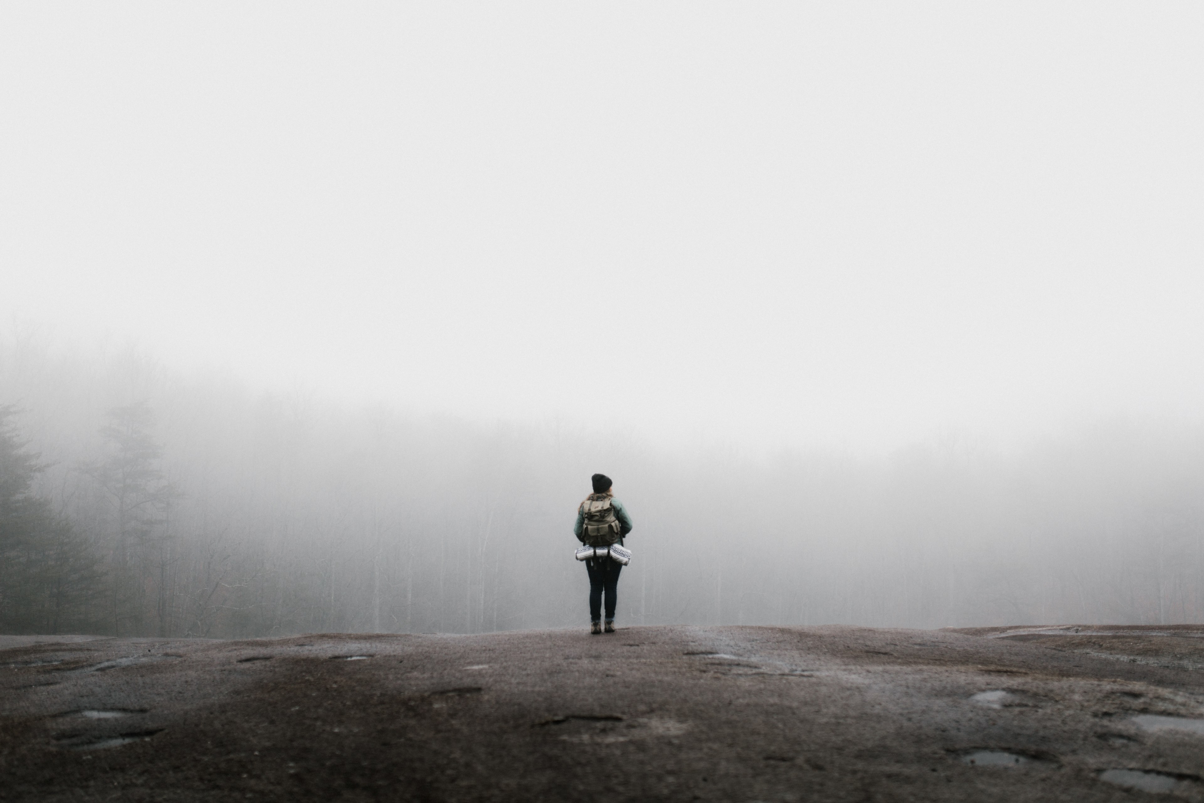 a woman standing on a rock wearing a backpack with her gear in it in the fog at stone mountain state park, musings of muir 4k, HD Wallpaper