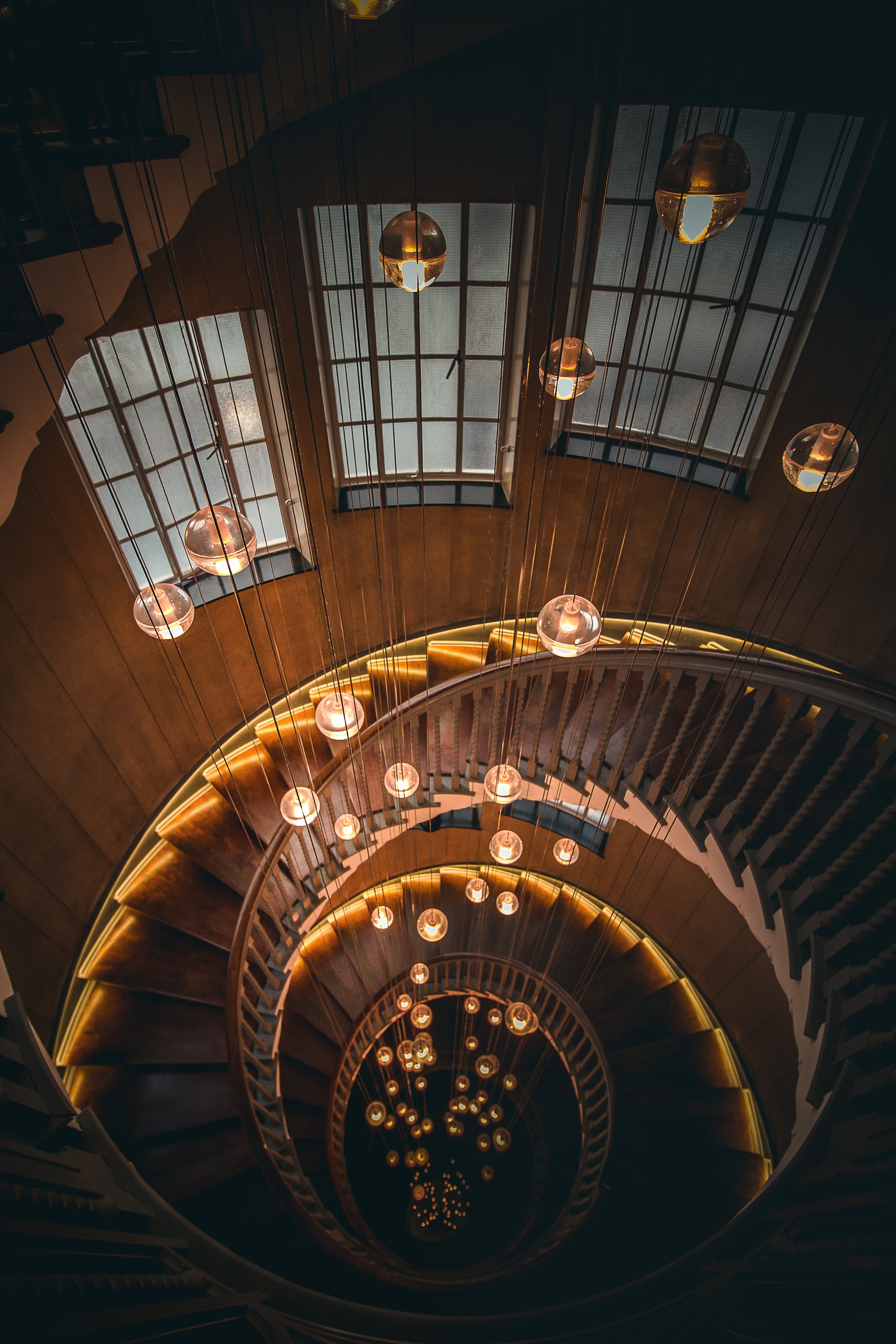 looking down on a spiral staircase with hanging lightbulbs at heals, going up 4k, Phone HD Wallpaper