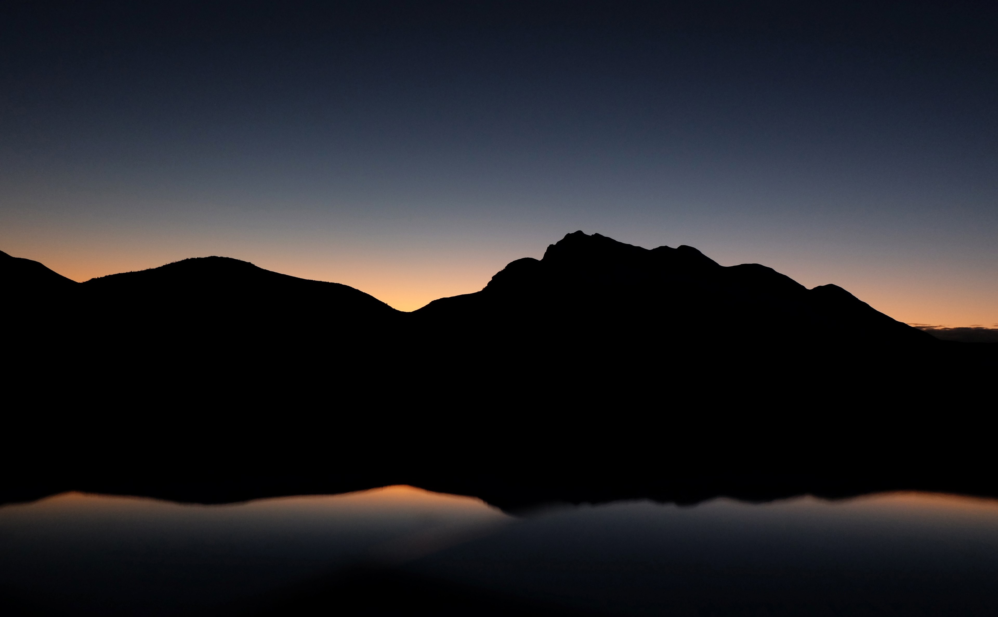 a silhouette of new york texas mountains during a dark sunset being reflected on still waters, the early bird catches the worm 4k, HD Wallpaper