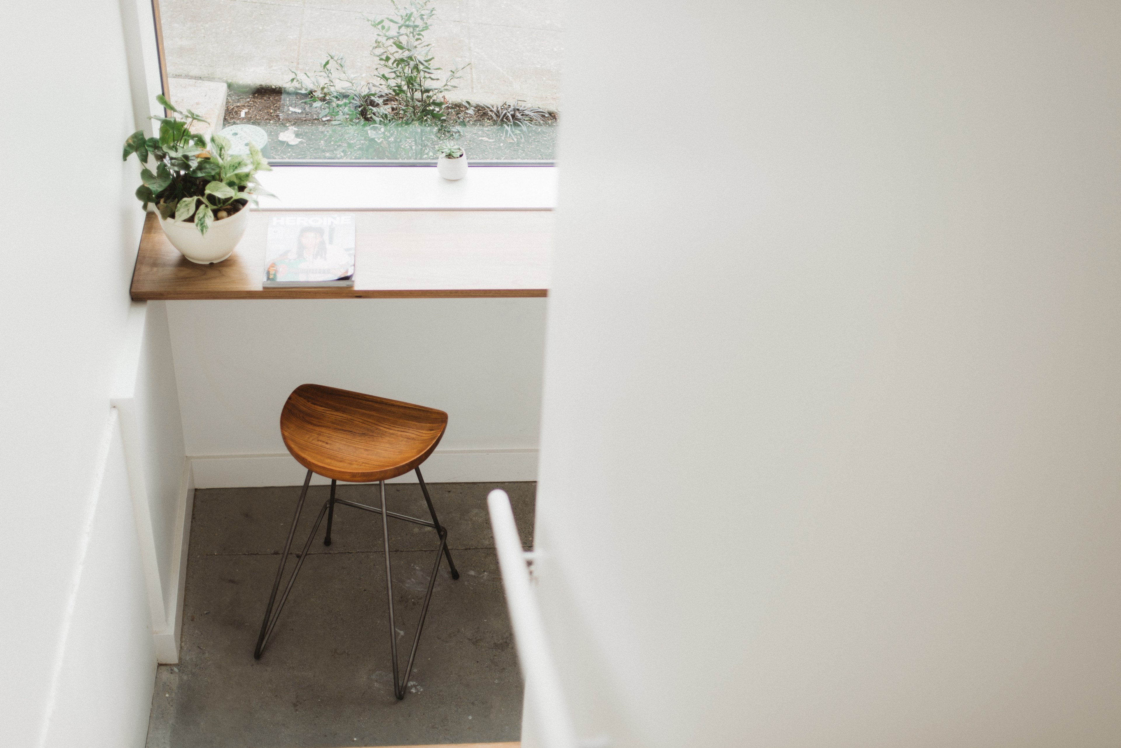 a desk area with a wooden stool two potted plants and a magazine overlooking a window, union coffee 4k, HD Wallpaper