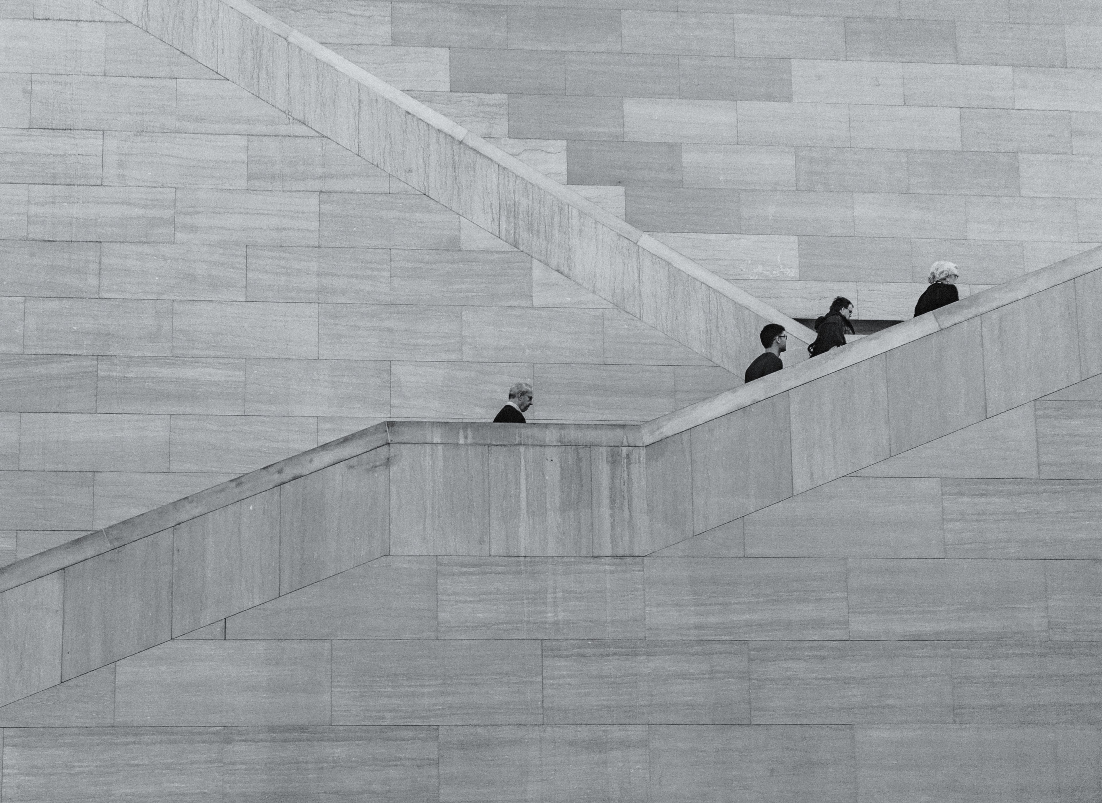 a black and white shot of people climbing up a tall concrete staircase, gloomy staircase 4k, HD Wallpaper