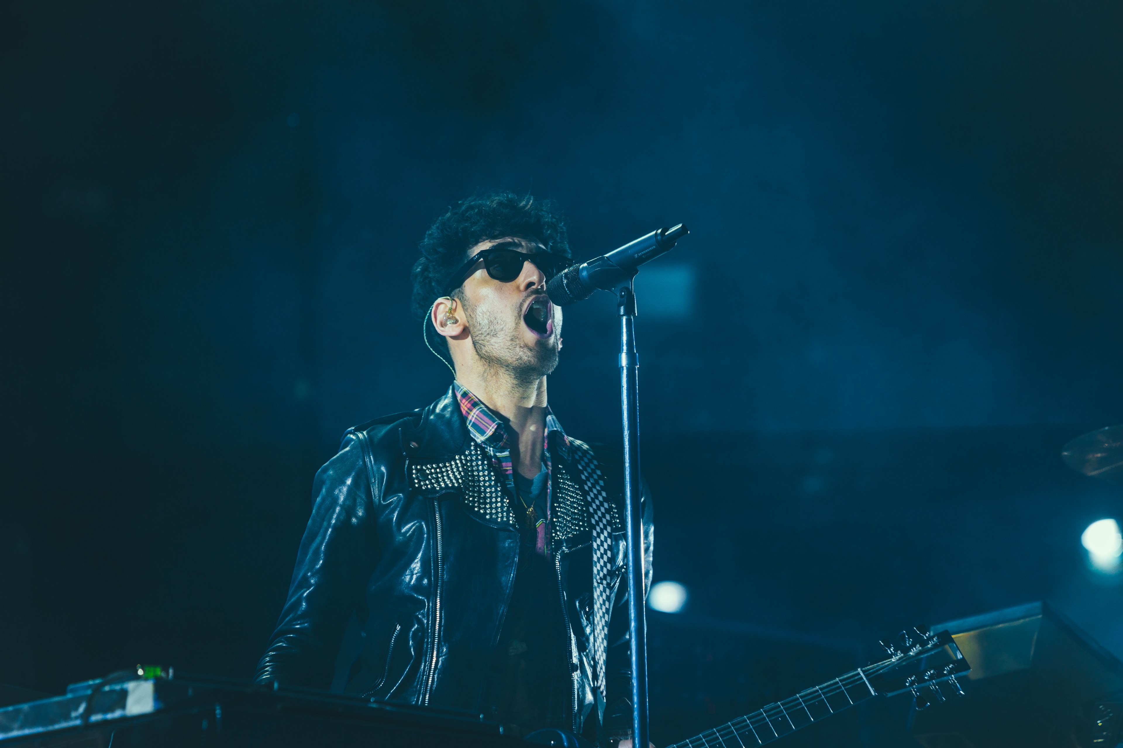 musician in a rock band sings into a microphone on stage, singer in concert 4k, HD Wallpaper