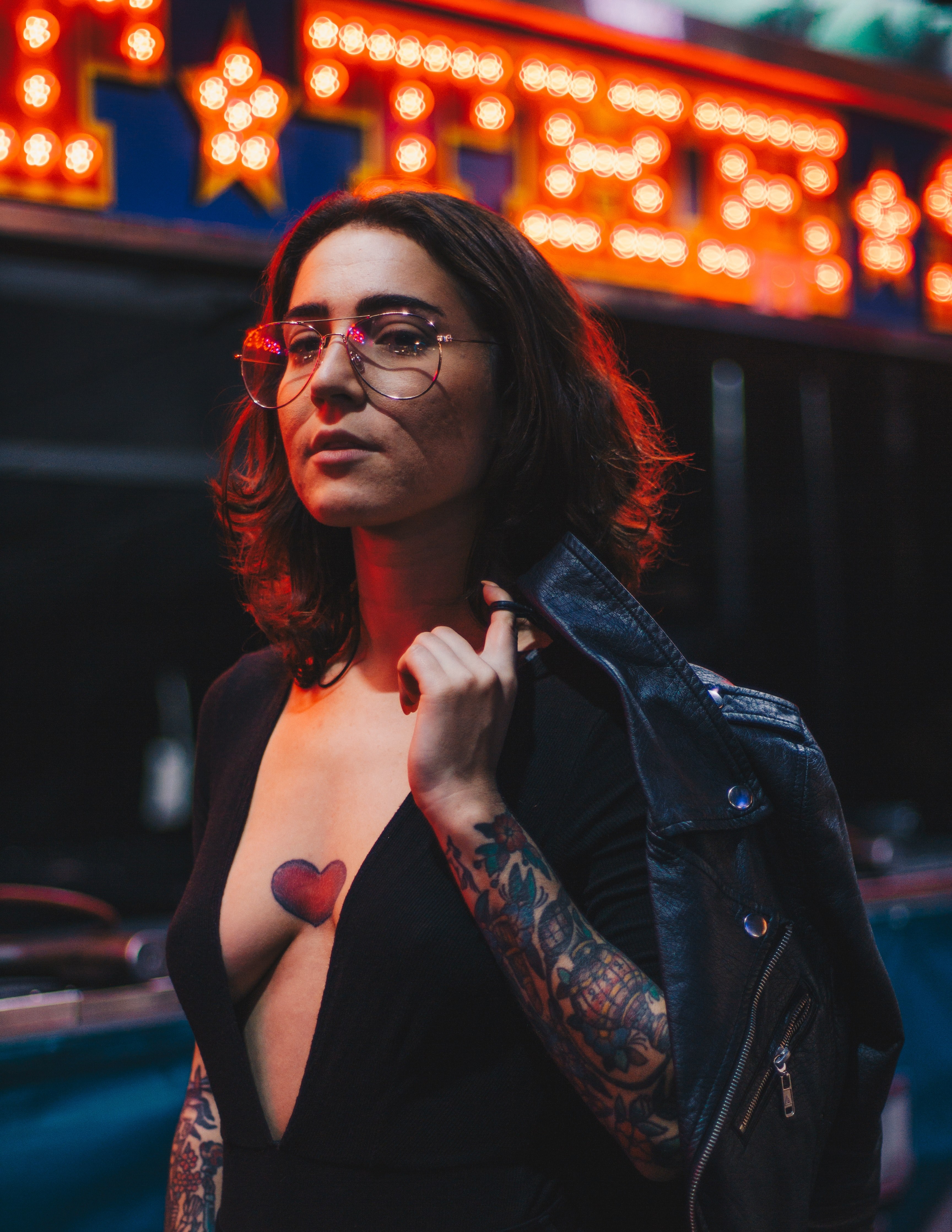 a tattooed woman in glasses with a heart inked on her exposed chest, ink heart on a womans chest 4k, Phone HD Wallpaper