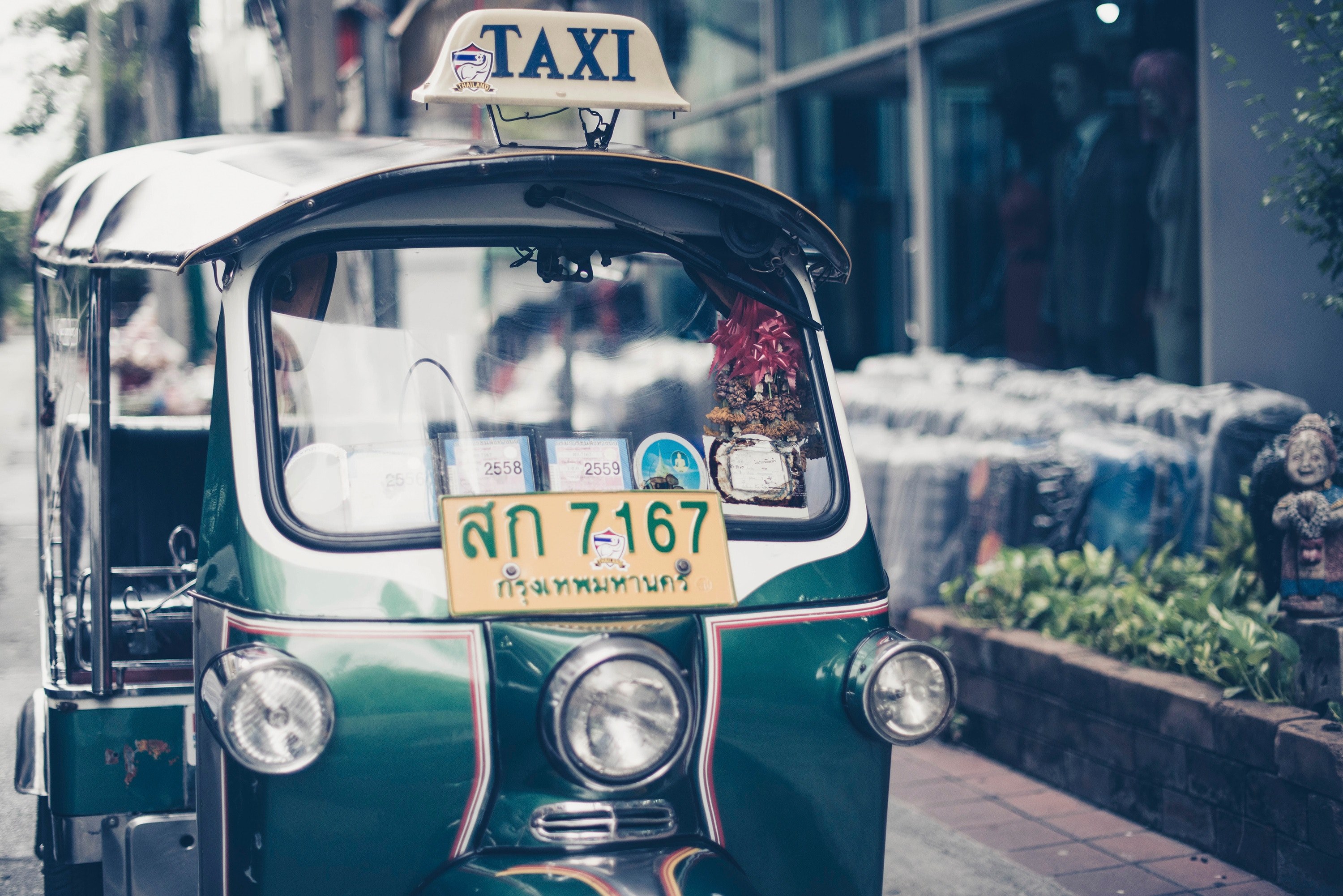 green taxi in bangkok with license plate on front sits outside of building near smiling statue, green taxi bangkok 4k, HD Wallpaper