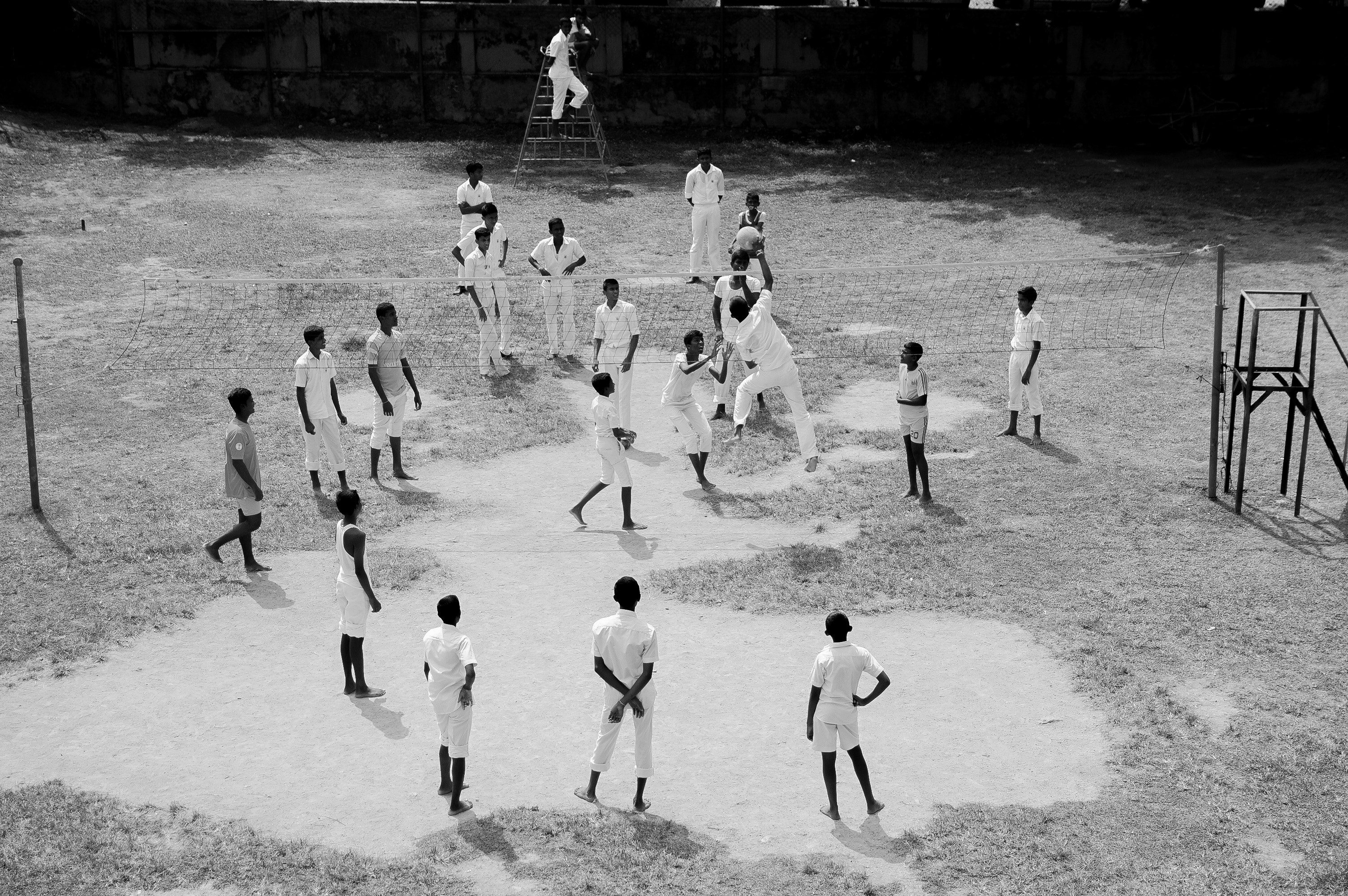 black and white shot of people playing volleyball in white uniforms on dusty ground sri lanka, game 4k, HD Wallpaper
