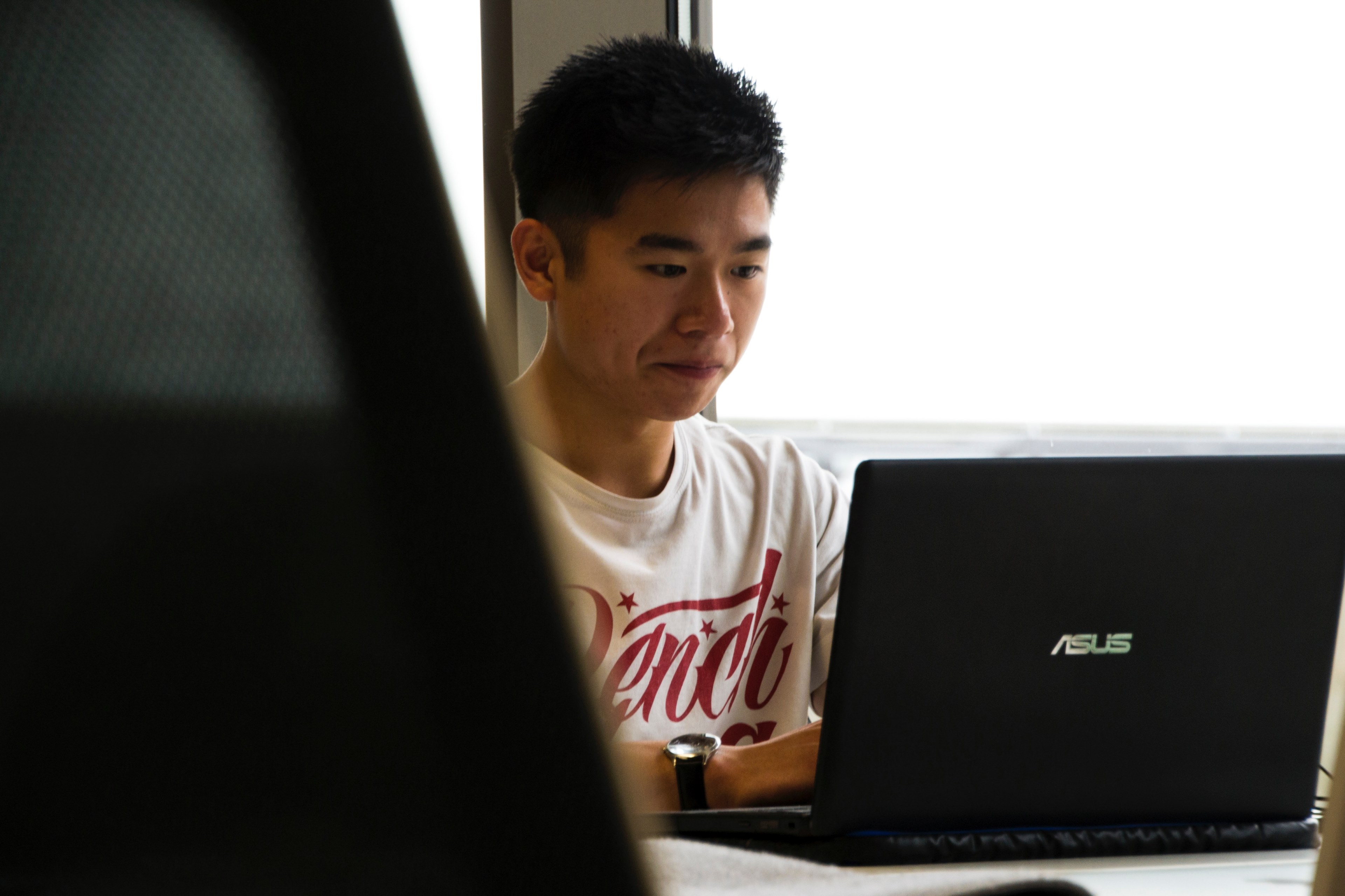 a young man sitting at a black laptop, developer at work 4k, HD Wallpaper