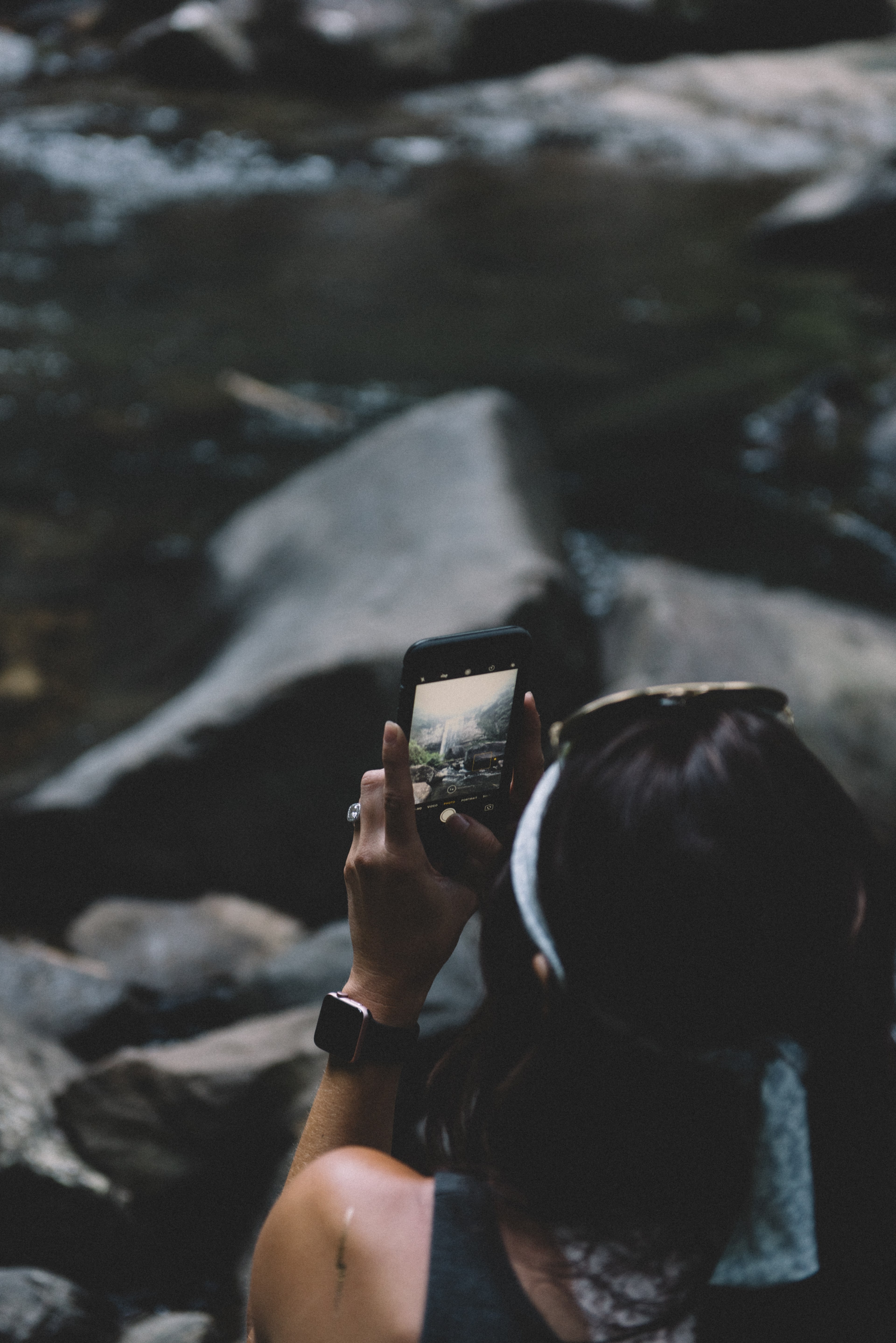 a woman sits on rocks in cloudland canyon state park taking a photo with an iphone, woman taking an iphone photo 4k, Phone HD Wallpaper