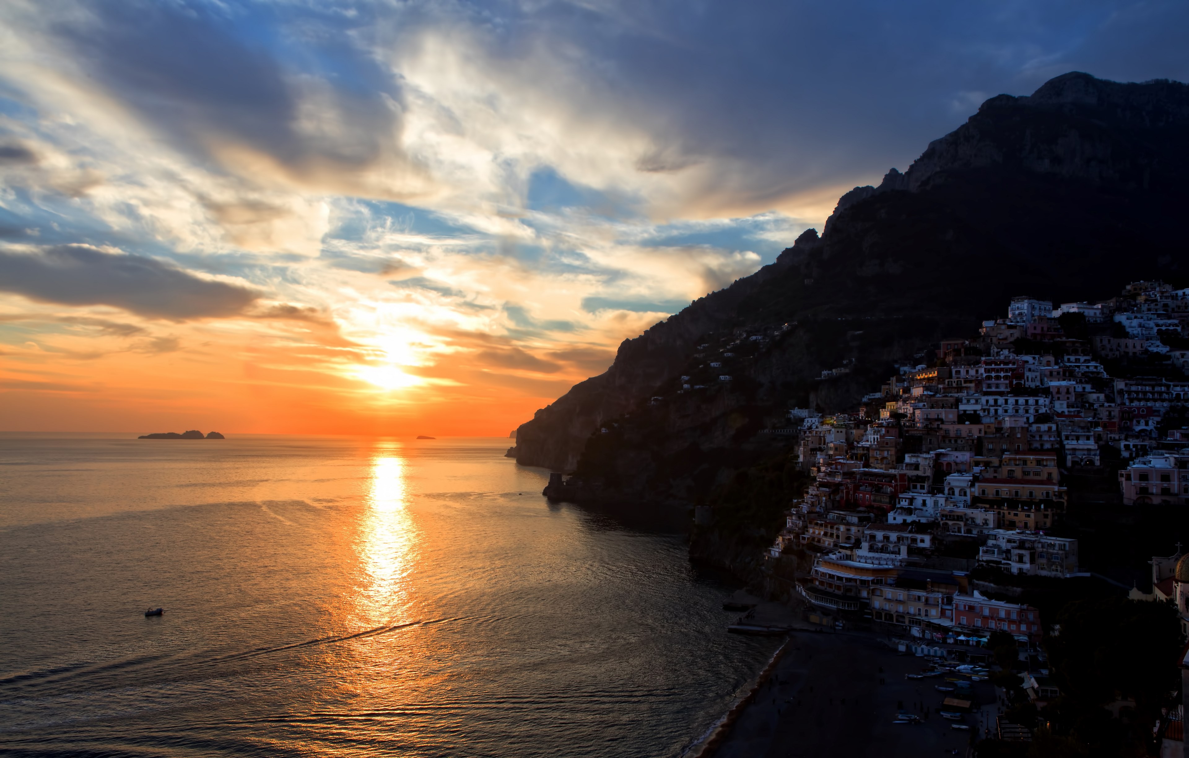 a cloudy orange sunset reflecting on the water by an oceanside town built on a hill, positanos sunset 4k, HD Wallpaper