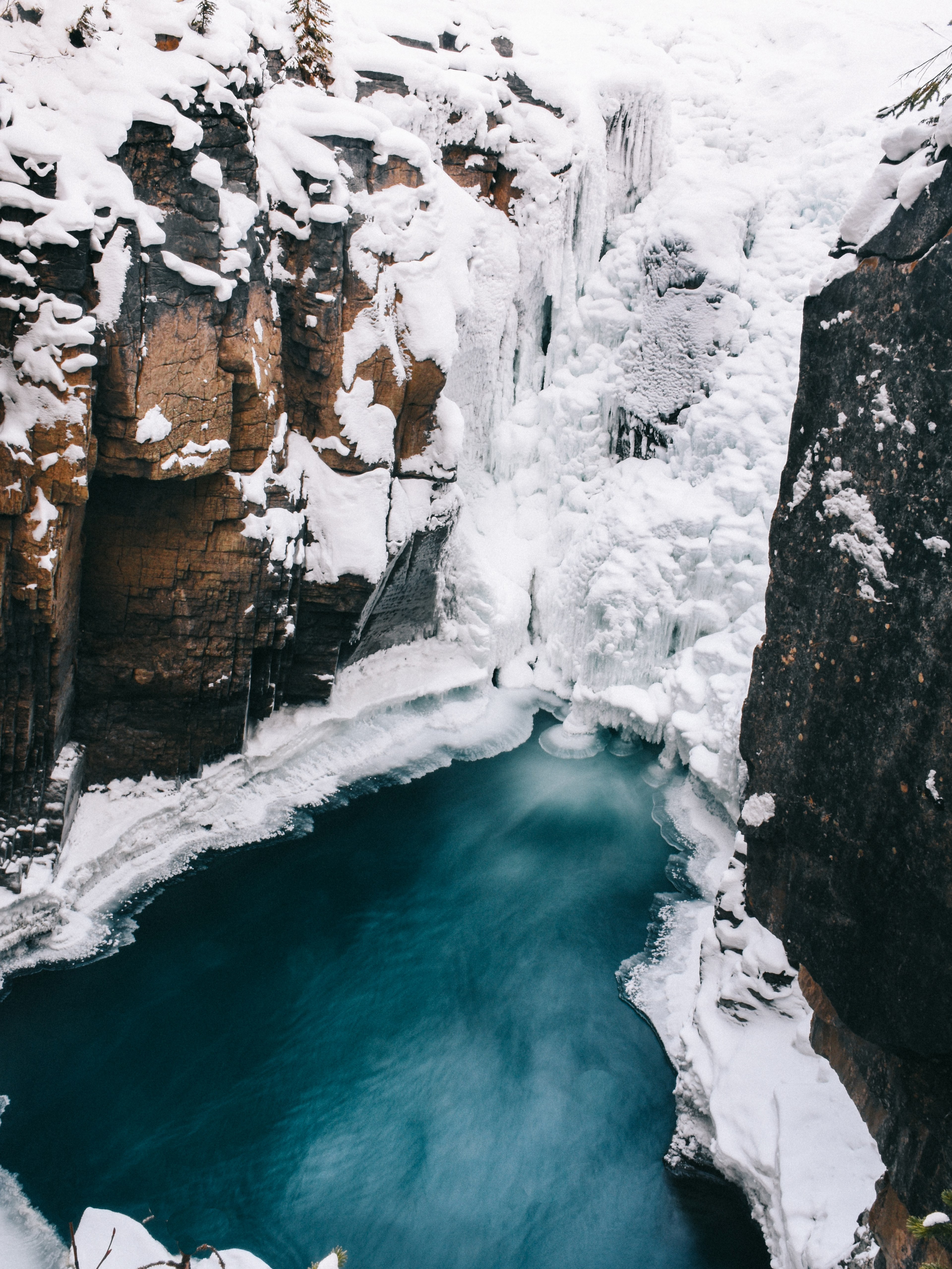 an icy mountain cliff is split by a frozen stream of water, an icy stream between cliffs 4k, Phone HD Wallpaper