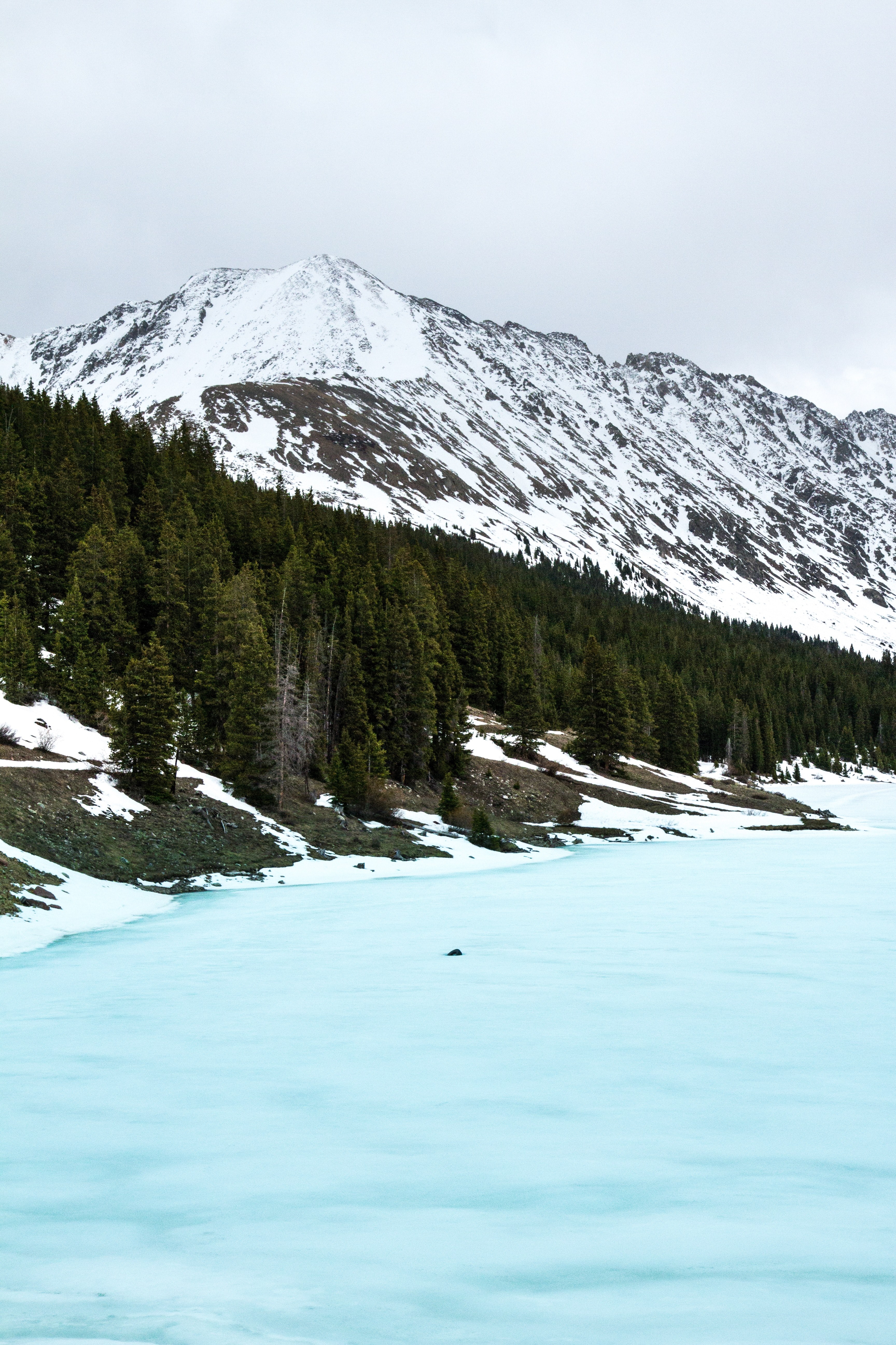 an icy blue half frozen lake in the mountains in summit county, tire in the lake 4k, Phone HD Wallpaper