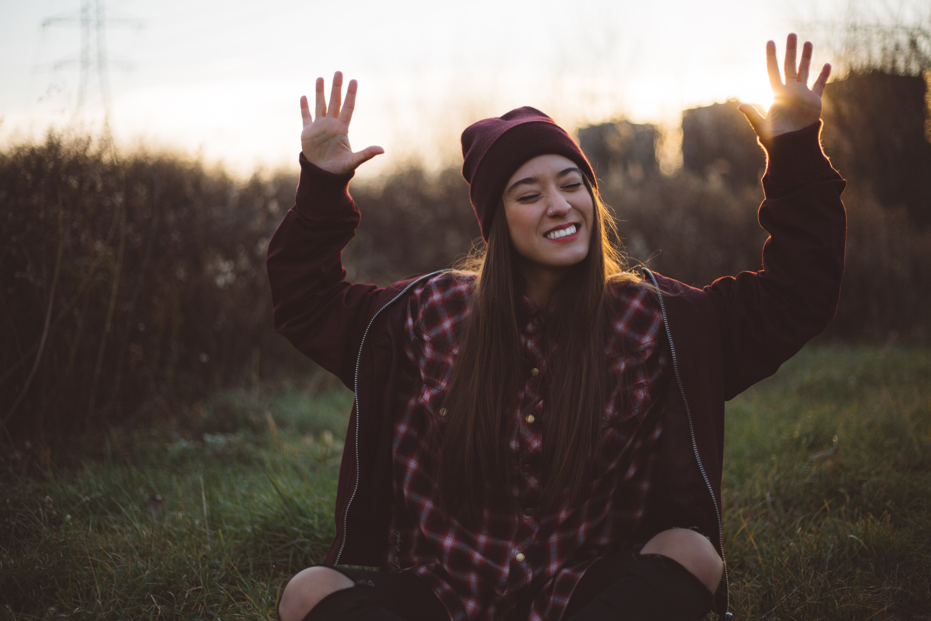 a happy woman sitting outside smiling with her hands raised to the sky, _catch the right light 4k, HD Wallpaper
