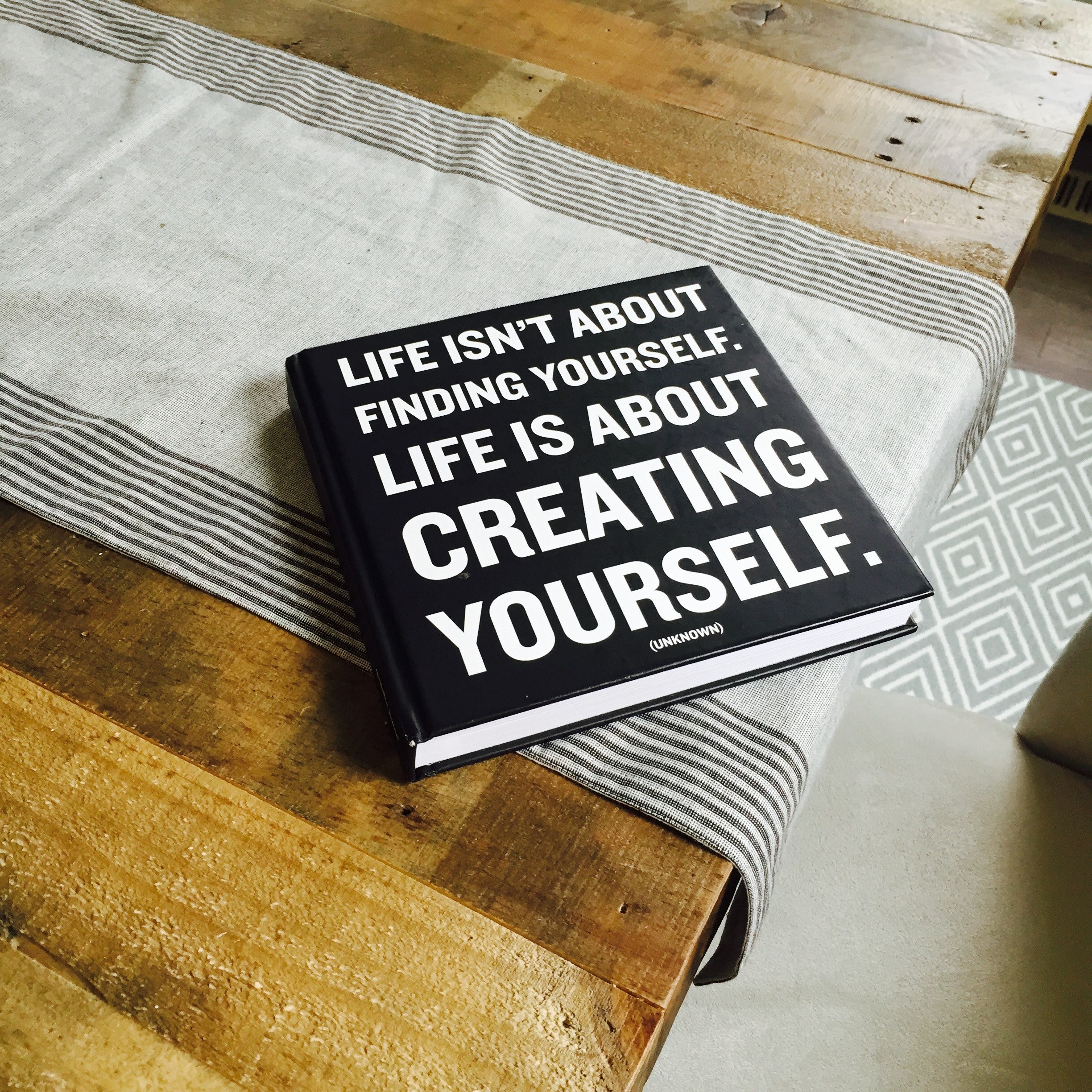 a black book with the title quotlife isnt about finding yourself life is about creating yourself_quot, book with motivational text 4k, HD Wallpaper