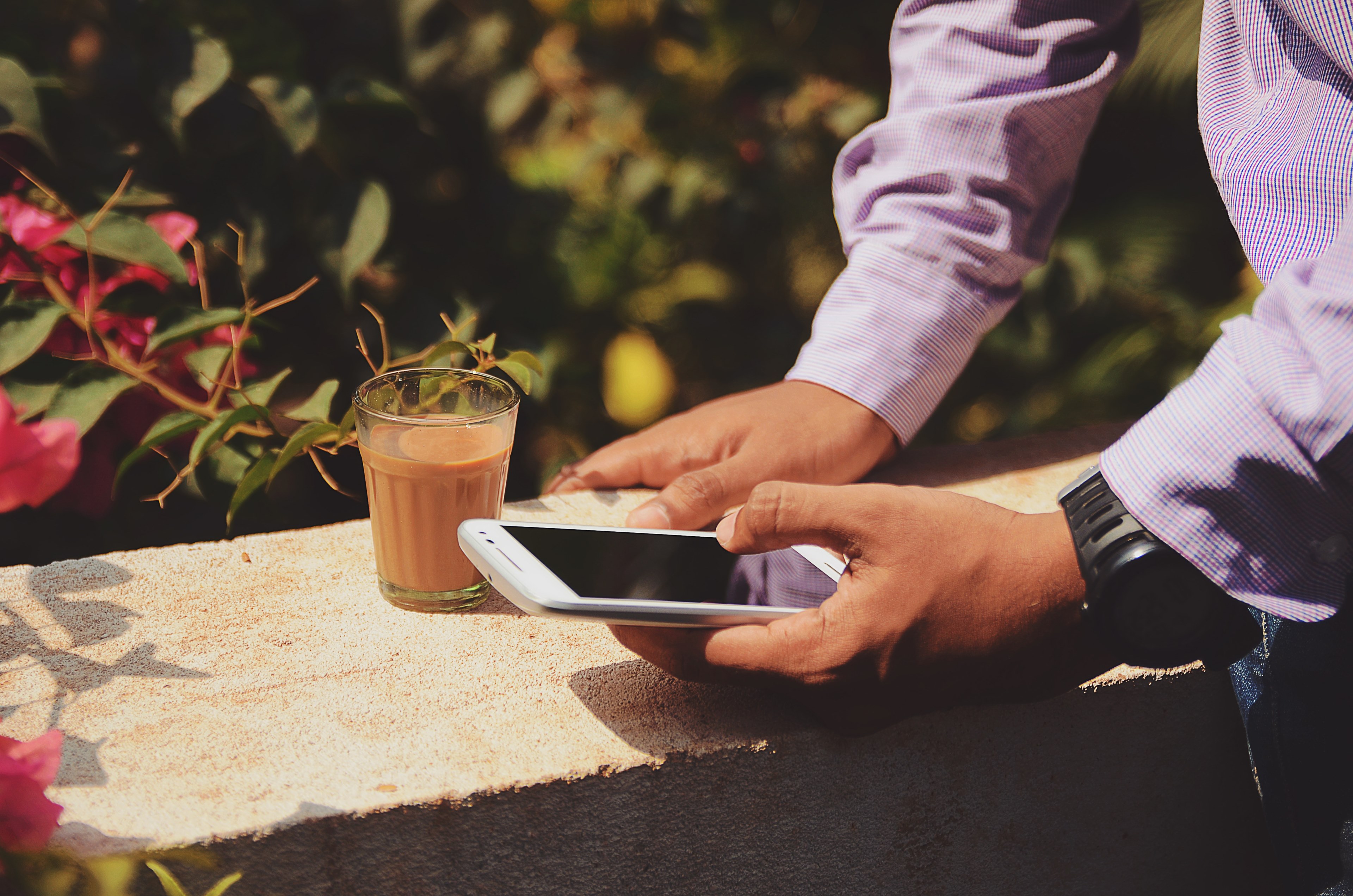 a man in a shirt seated on a concrete ledge using a smartphone and drinking coffee, businessman with coffee outdoors 4k, HD Wallpaper