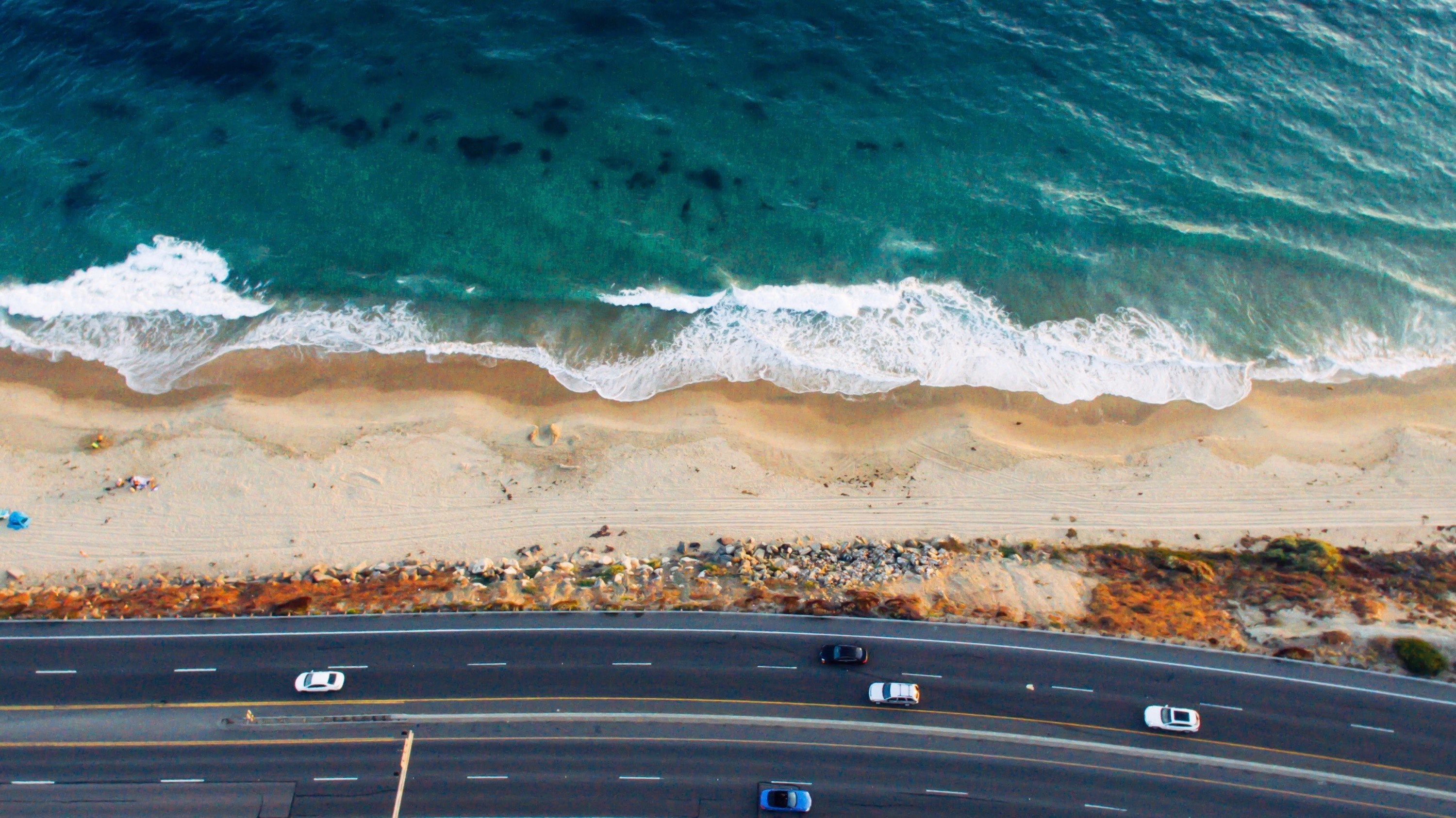 drone view of a highway with cars by the sandy beach shoreline at crystal cove state park, man and wild 4k, HD Wallpaper