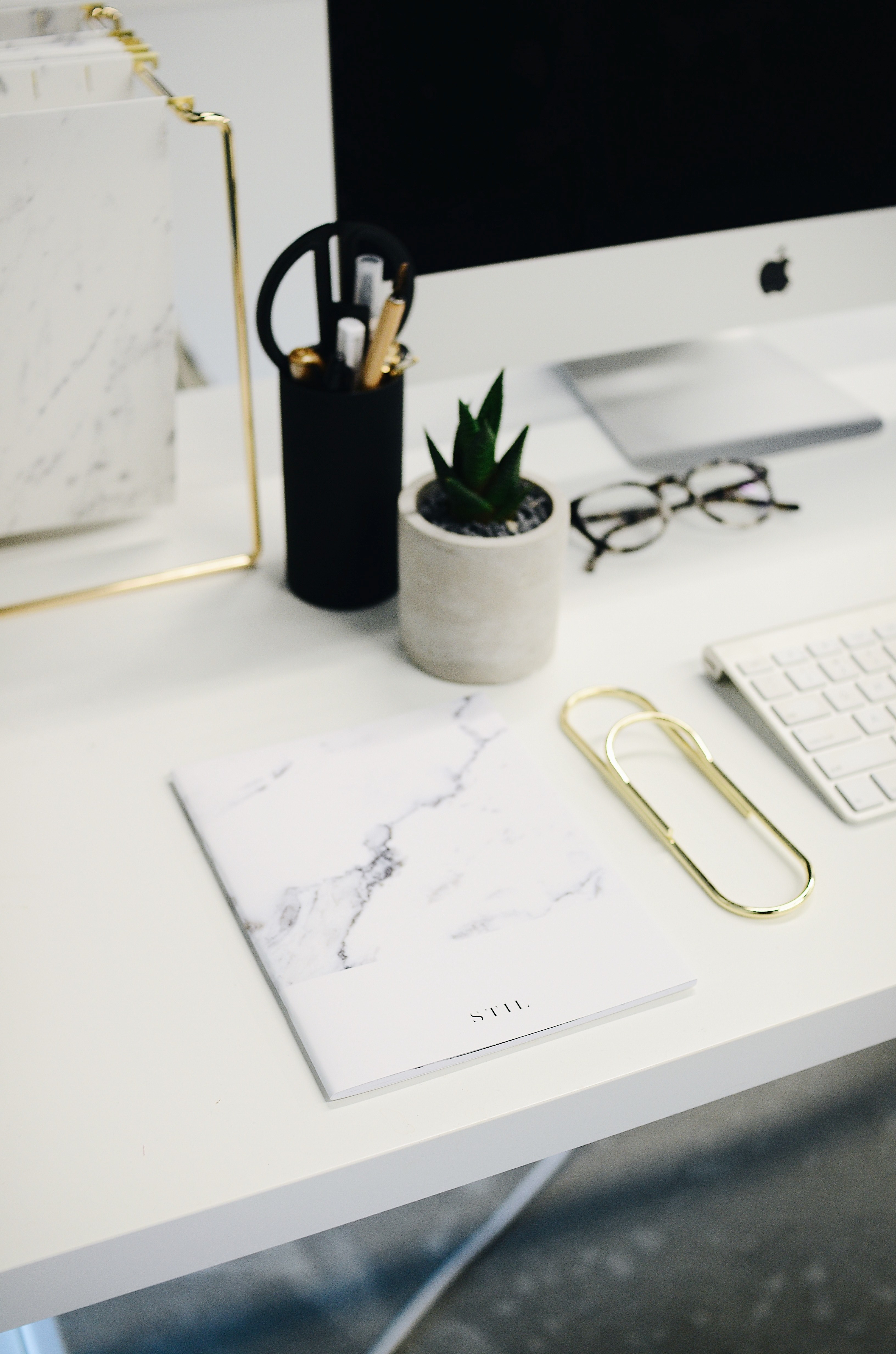 a book and a large paper clip on a computer desk with an imac, a marble journal 4k, Phone HD Wallpaper