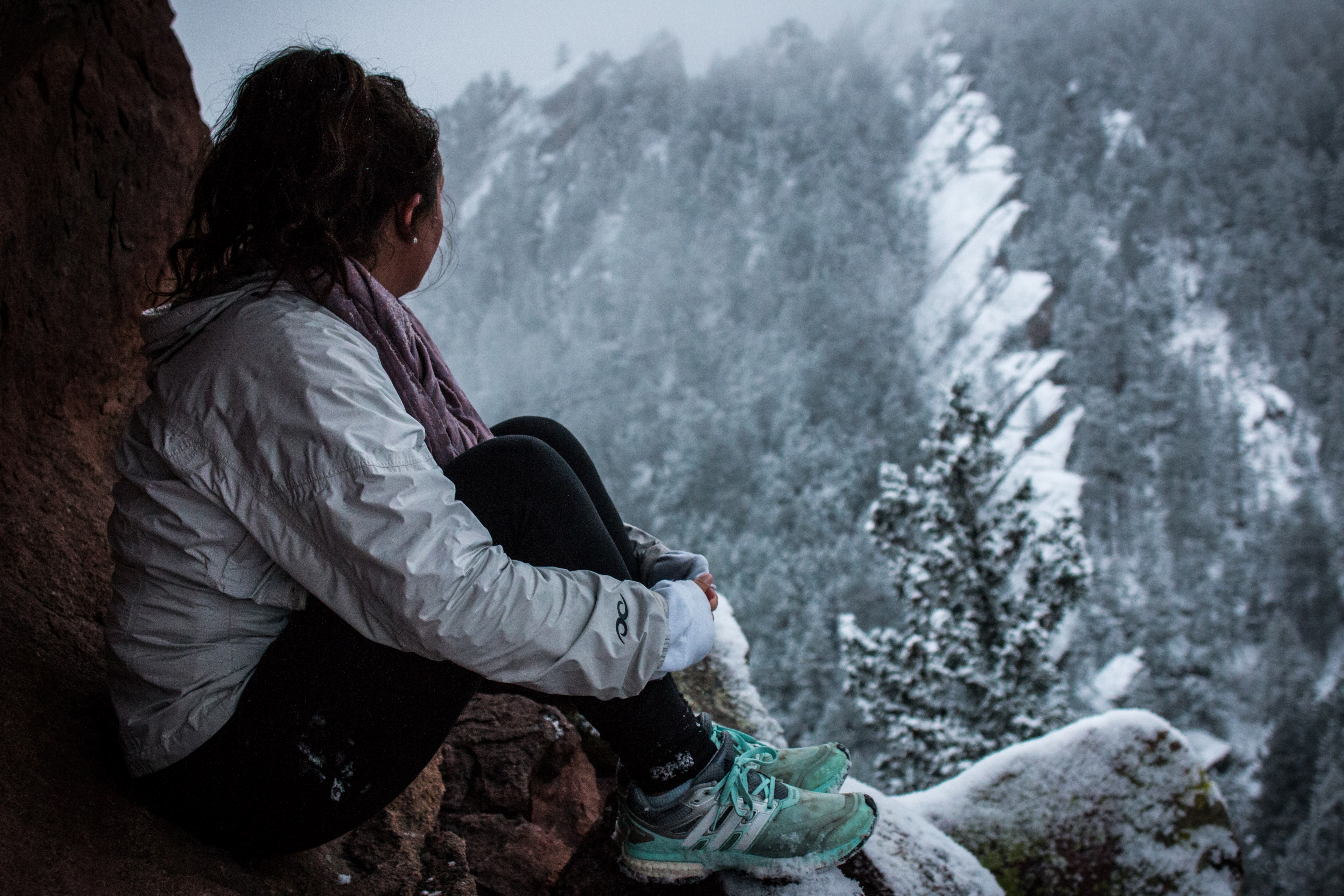 a female hiker wearing blue sneakers a white jacket and purple scarf sitting on a rock looking out into the snowy mountains of the chautauqua trail, a snowy hike 4k, HD Wallpaper