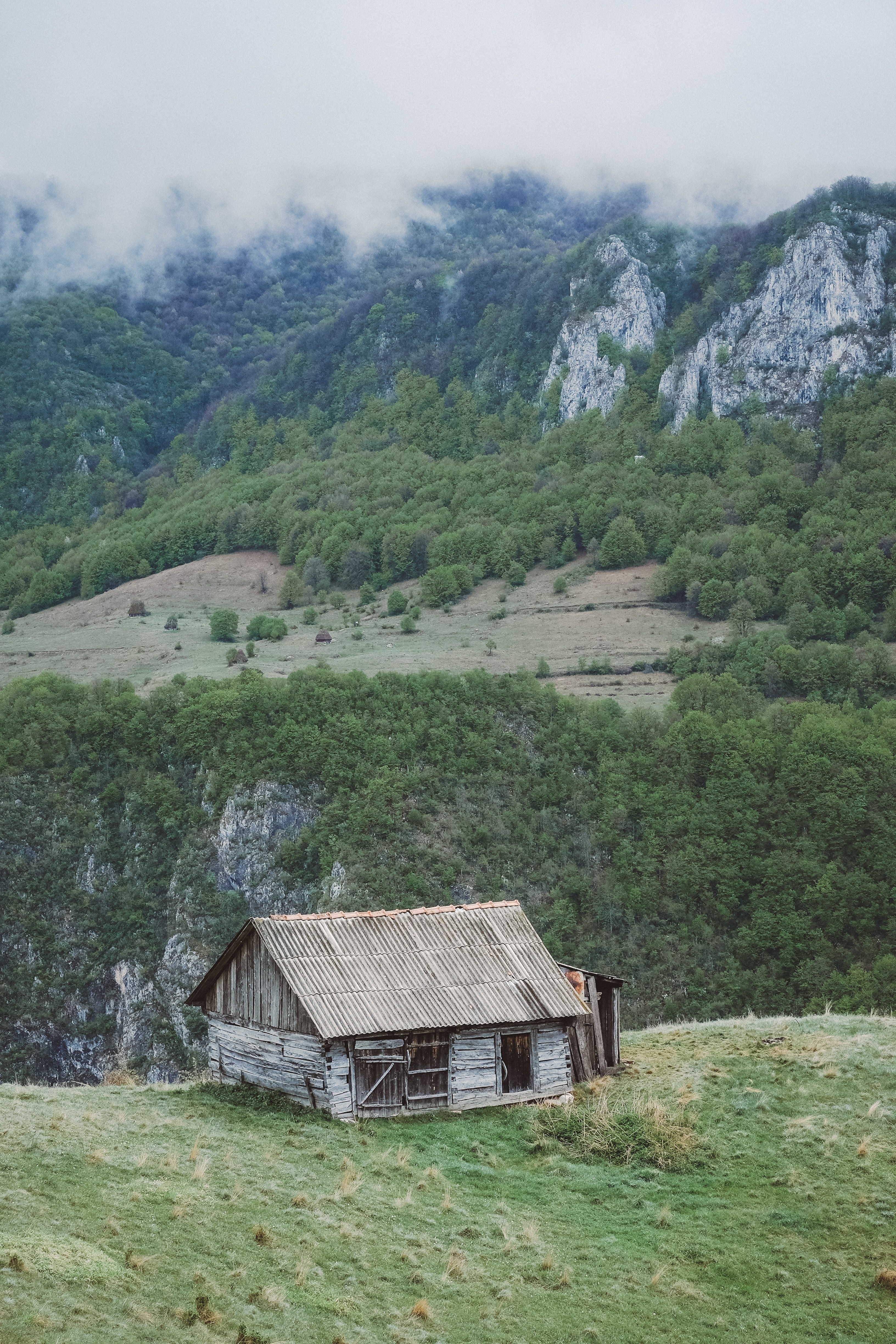 a dilapidated cabin on a grassy hill in the mountains, abandoned cabin on a hill 4k, Phone HD Wallpaper