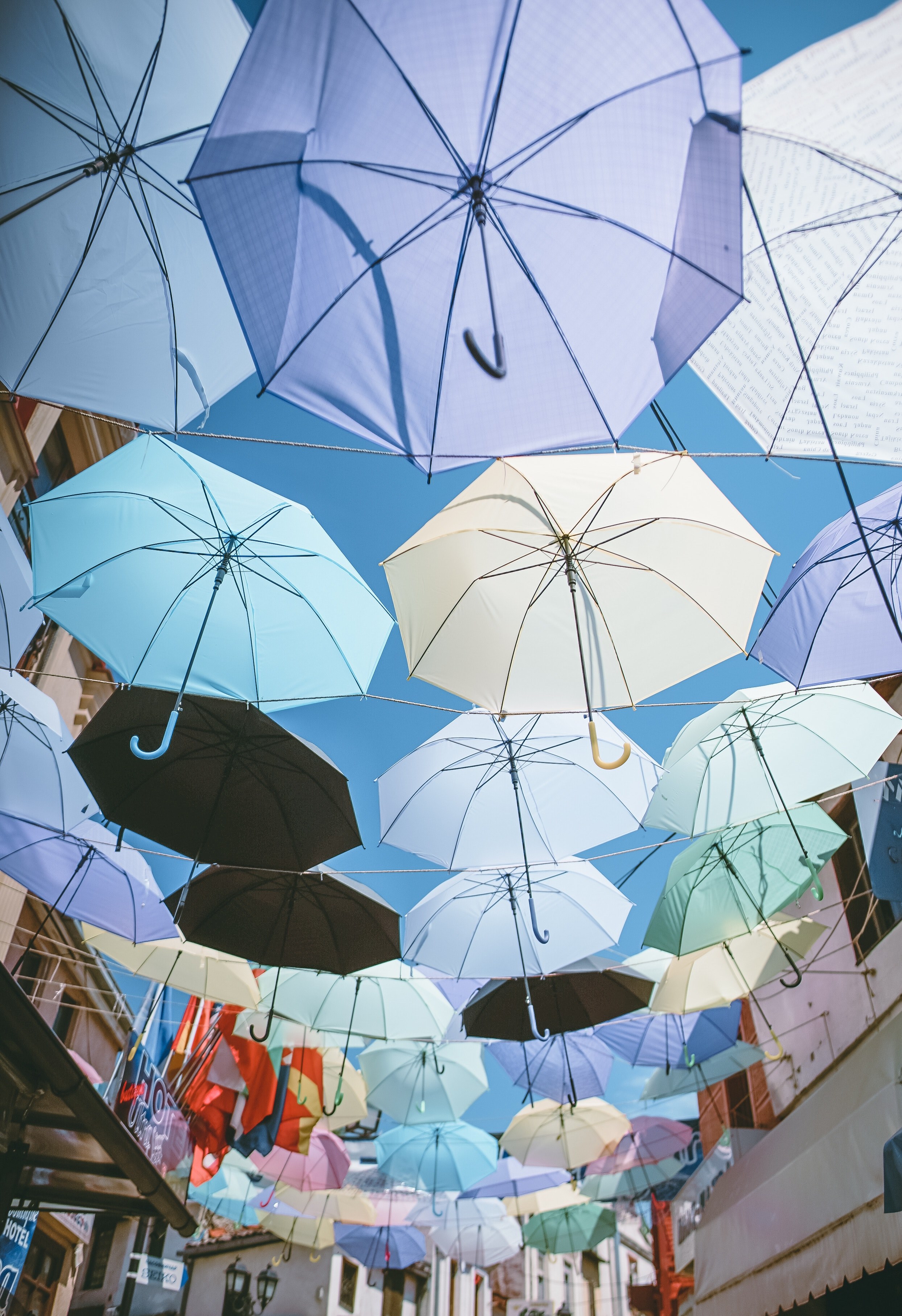 a number of colorful umbrellas suspended in the air over a street, colours in the sky 4k, Phone HD Wallpaper