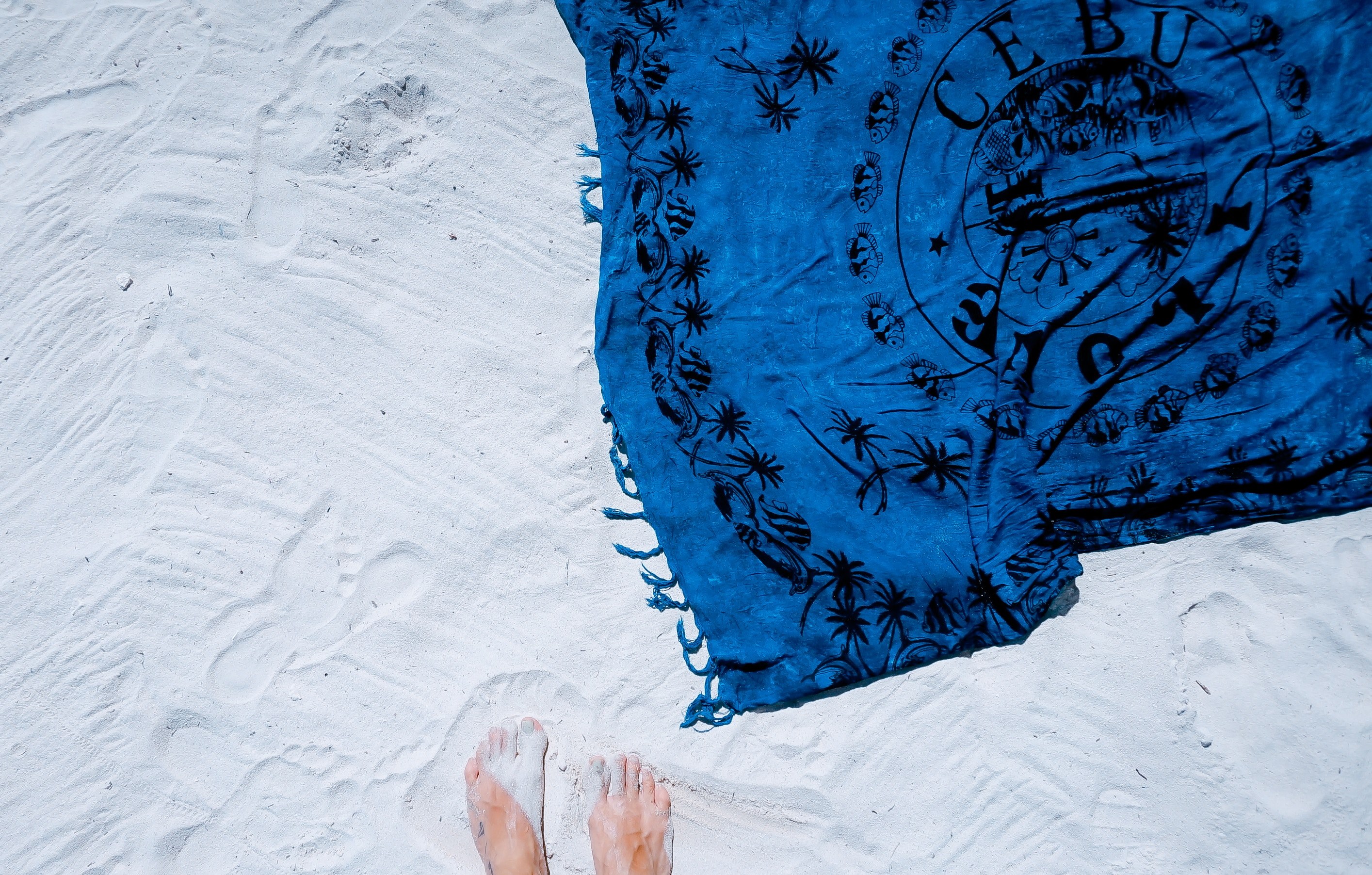 an overhead shot of a persons feet in the white sand next to a blue towel, standing in the fine sand 4k, HD Wallpaper