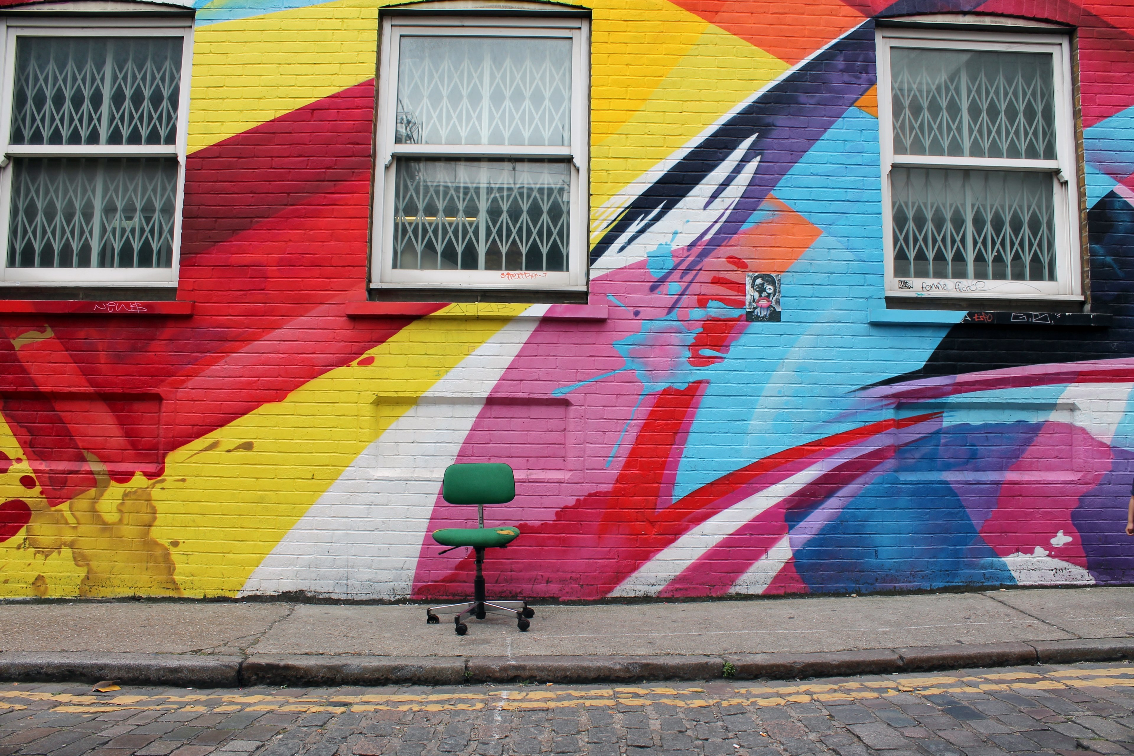 green chair sits in front of colorful graffiti on brick building with three windows, chair in front of graffiti 4k, HD Wallpaper