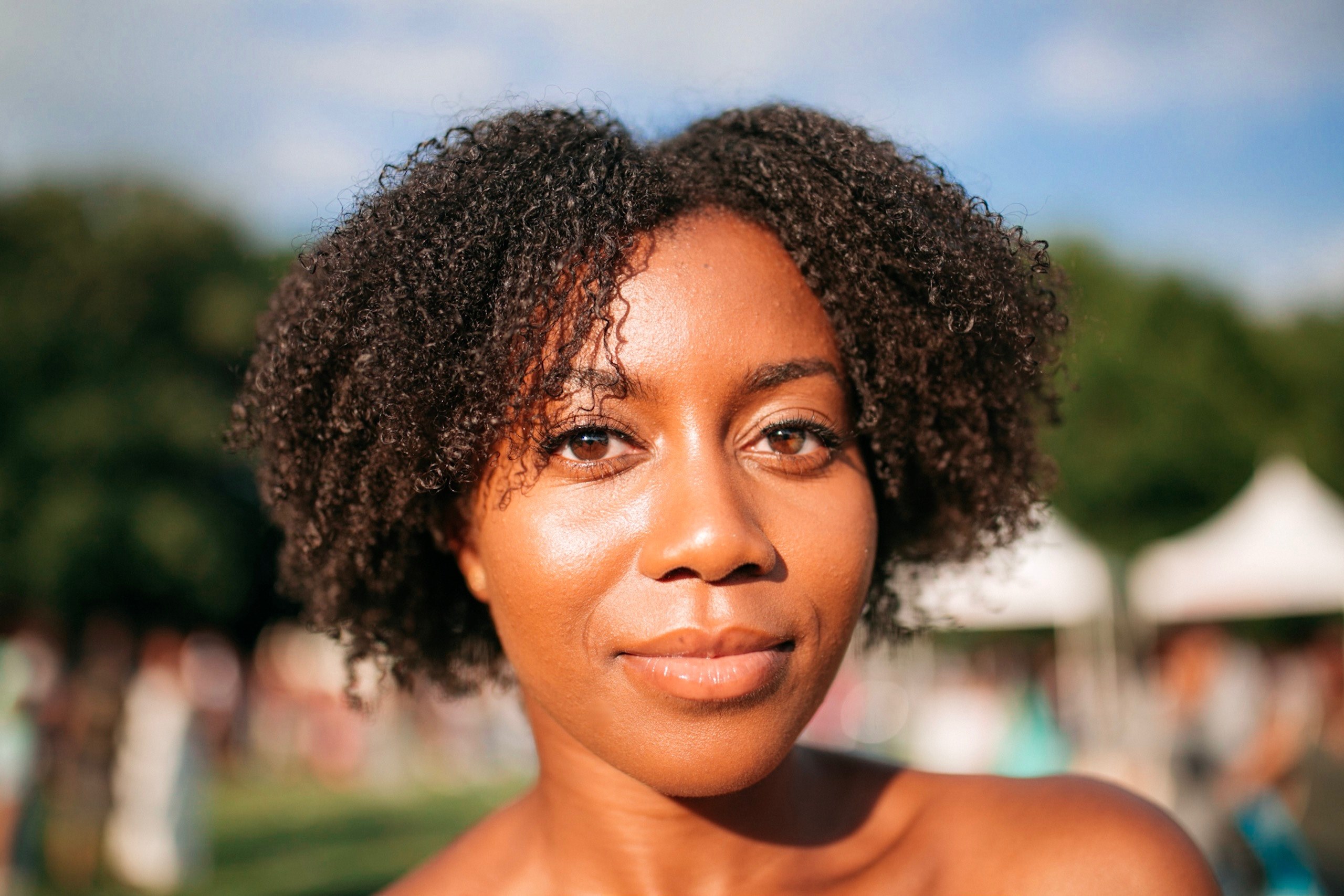 happy woman with curly natural hair smiling softly outside, curlfest 4k, HD Wallpaper