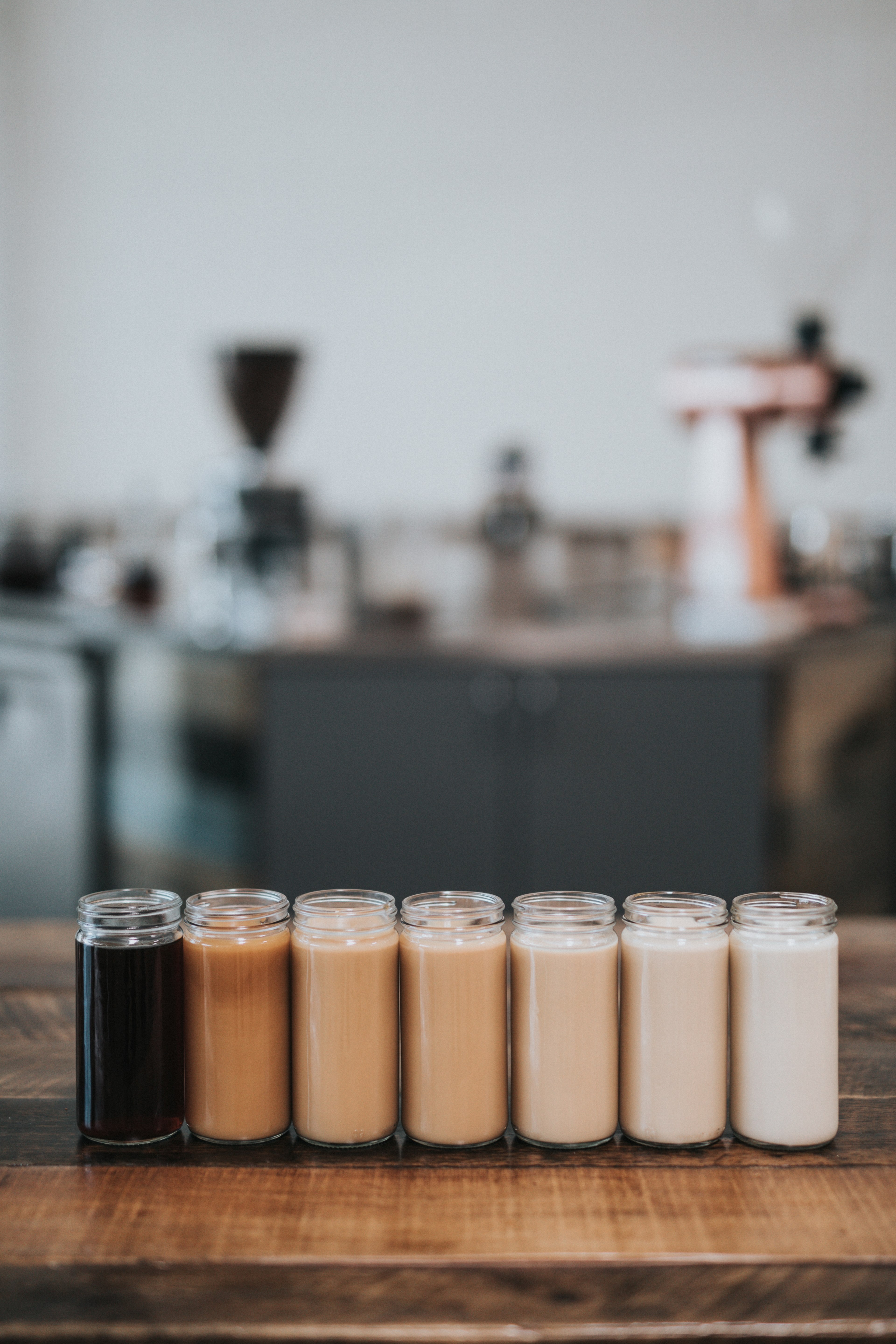 scented candles in various shades of brown standing in a row on a wooden surface, brown scented candles 4k, Phone HD Wallpaper